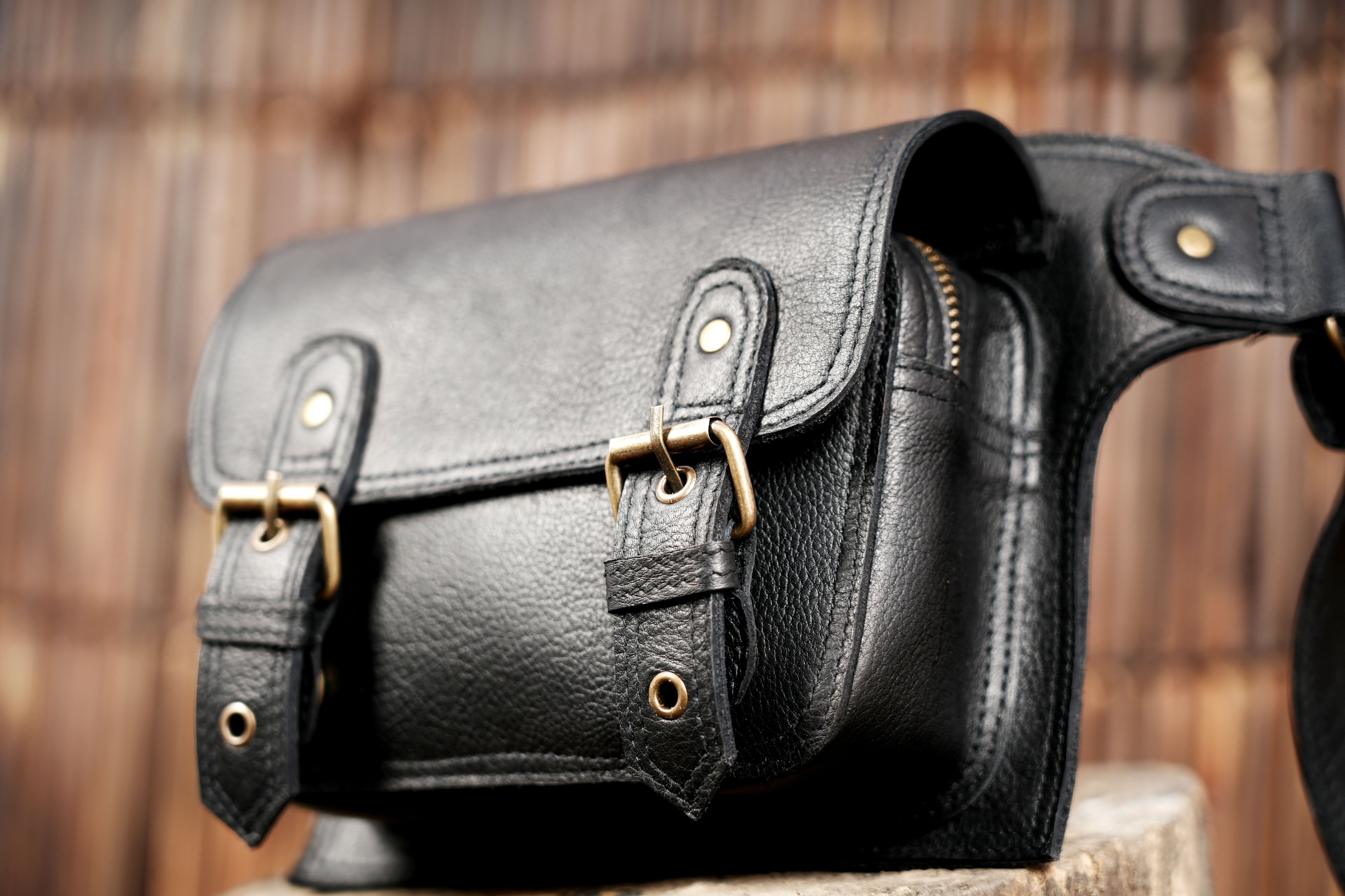"Classic black leather waist pouch with brass hardware"