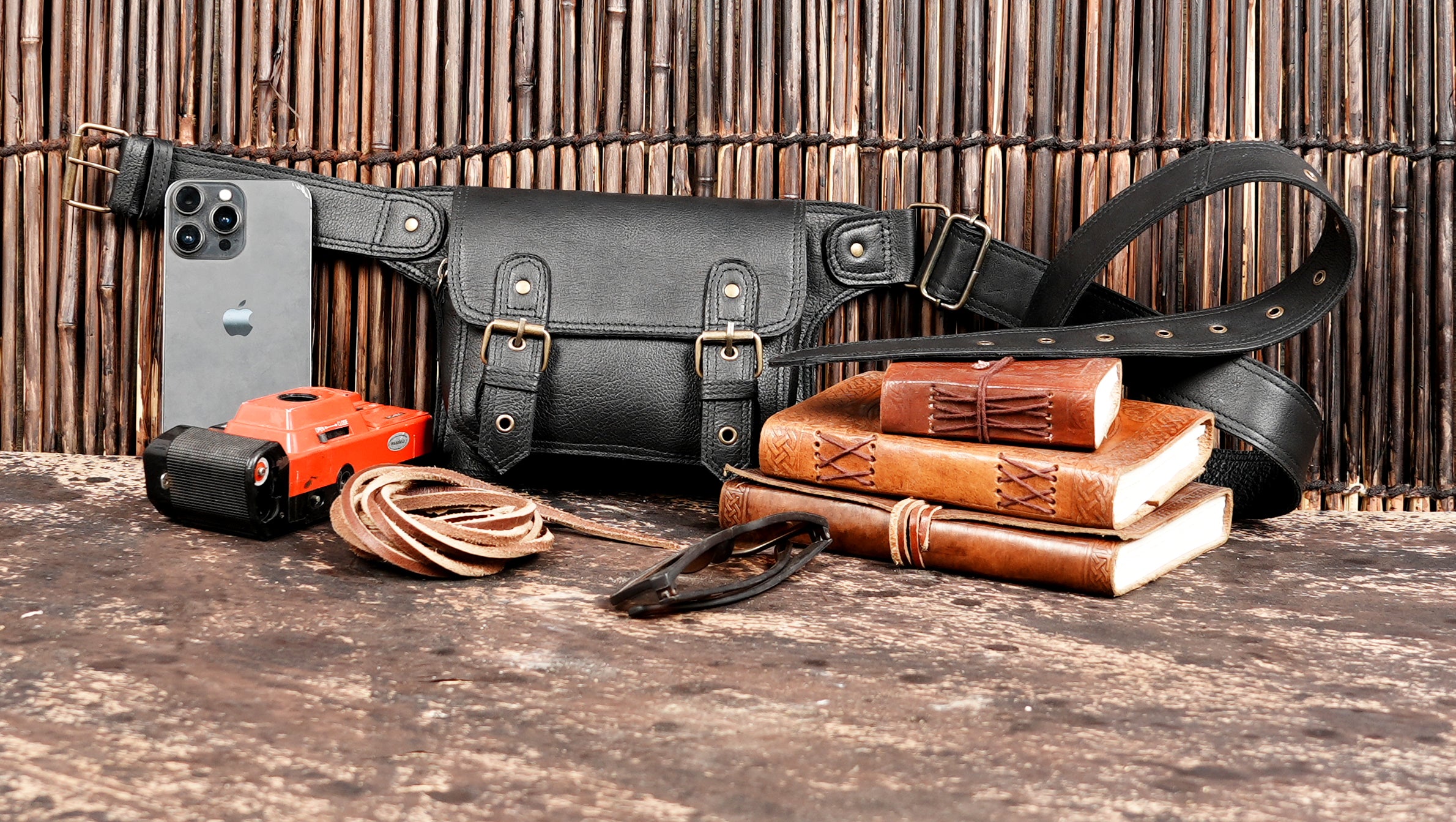 "Black leather money belt with front flap and buckle straps"