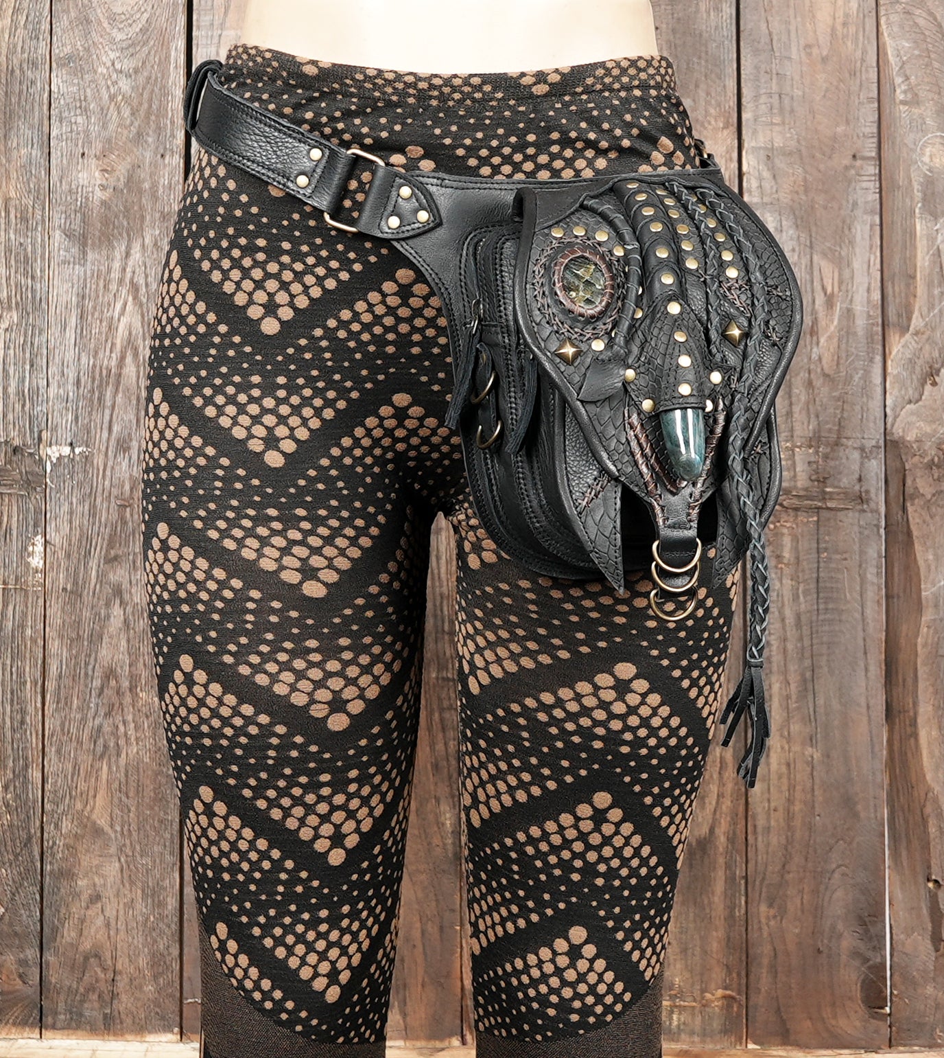 "Fashionable black leather hip bag with gemstone centerpiece"