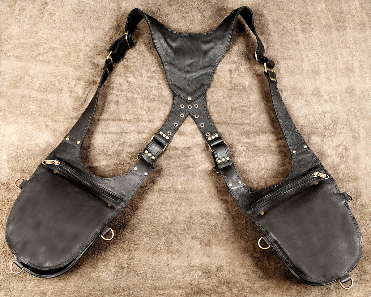 Unisex black leather utility harness bag with two front pouches and orange leather embellishments.