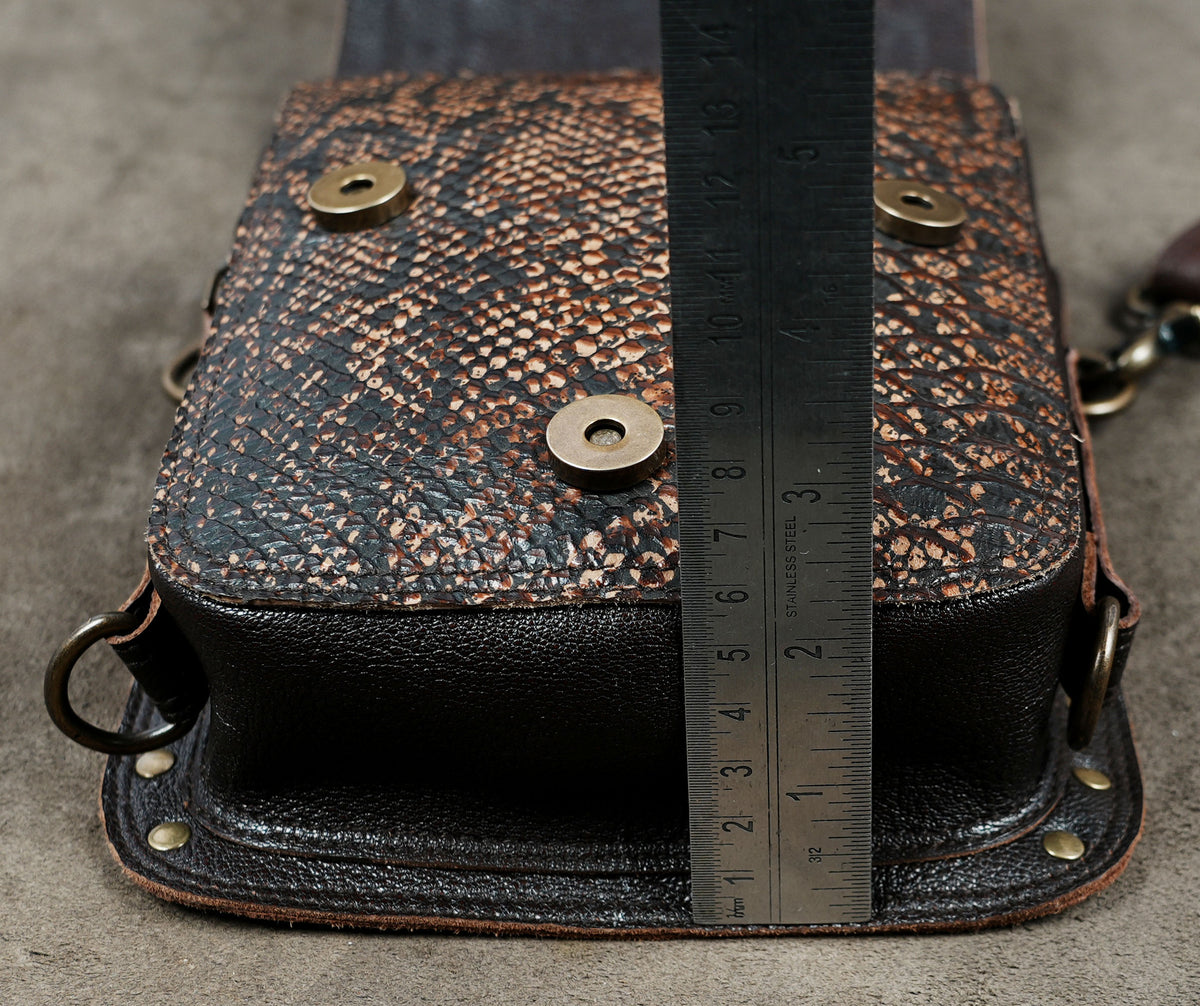 Gothic brown leather holster bag with gemstone centerpiece and intricate studwork.