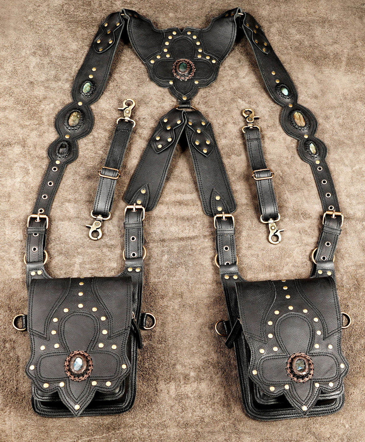 Alternative fashion leather harness bag with ornate flaps and metal studs
