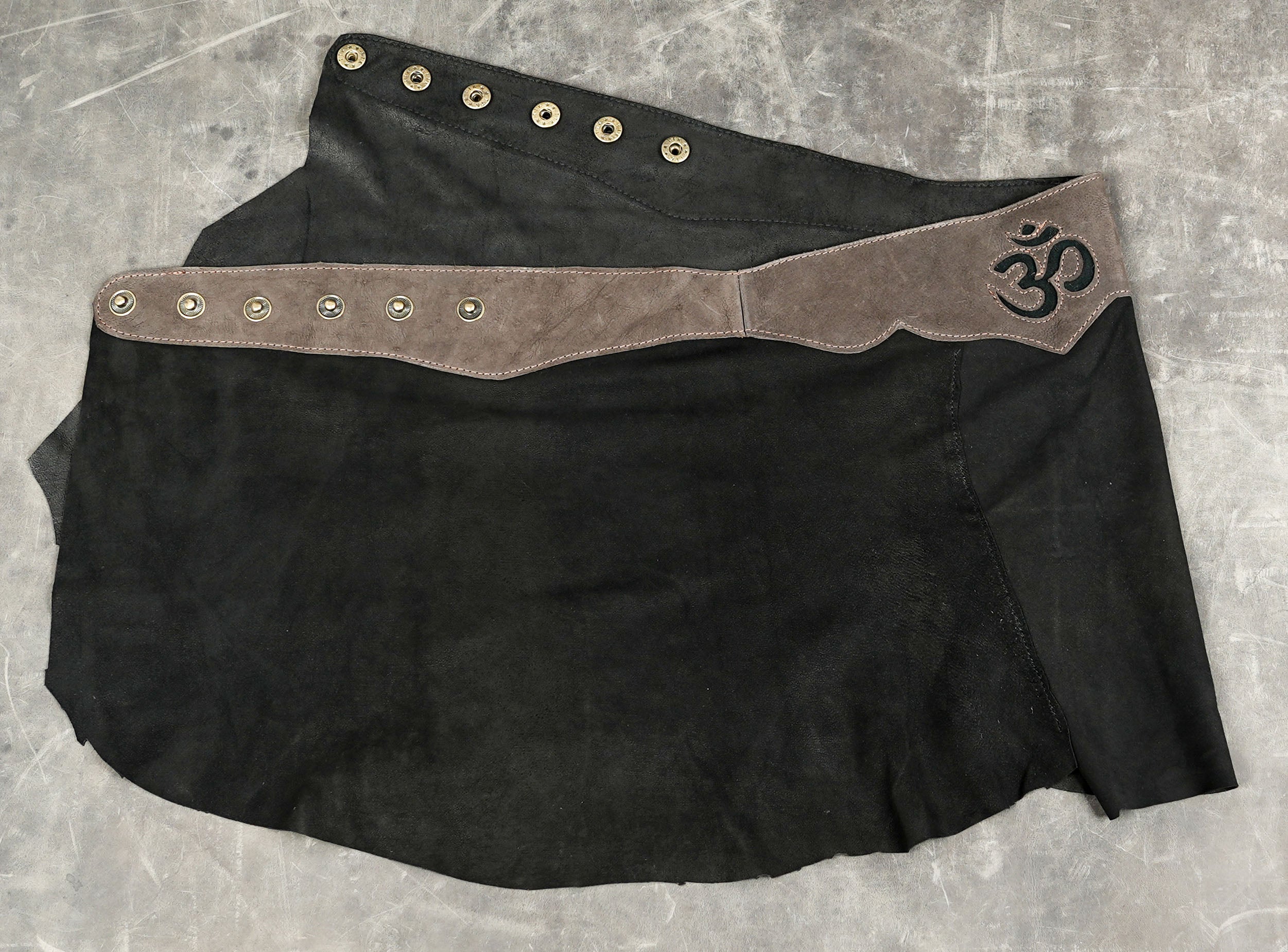 Handcrafted leather festival skirt styled on stone background