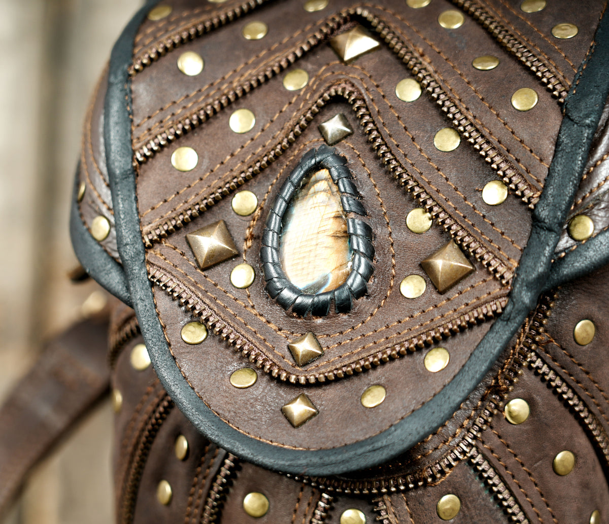 Brown leather rave outfit accessory with adjustable harness straps and gemstone pockets