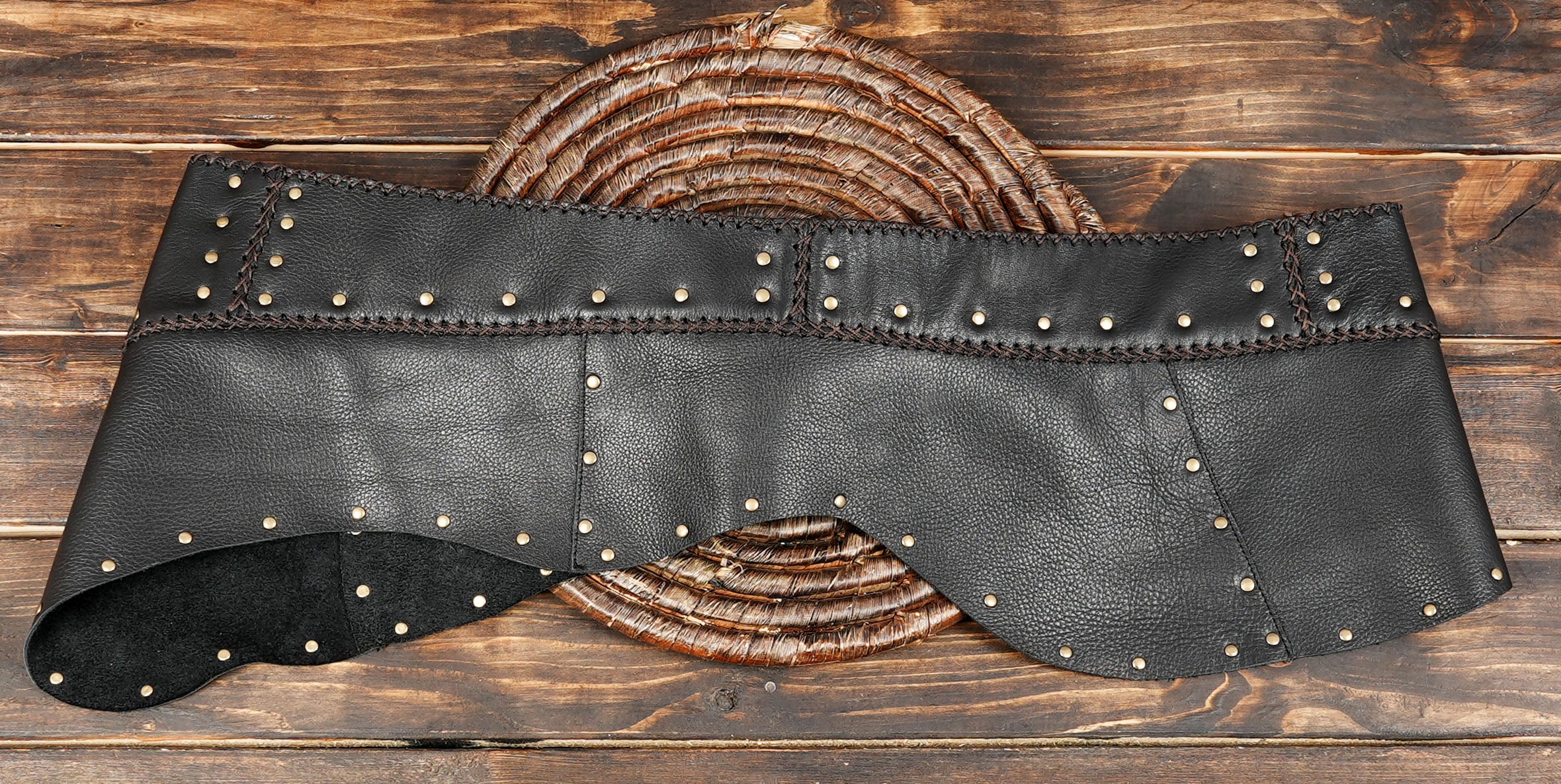 Handmade black leather mini skirt with brass stud rows