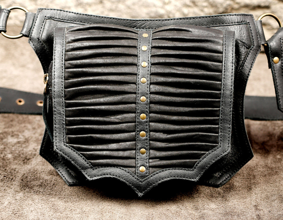 Close look at black leather belt bag with gathered front and brass studs
