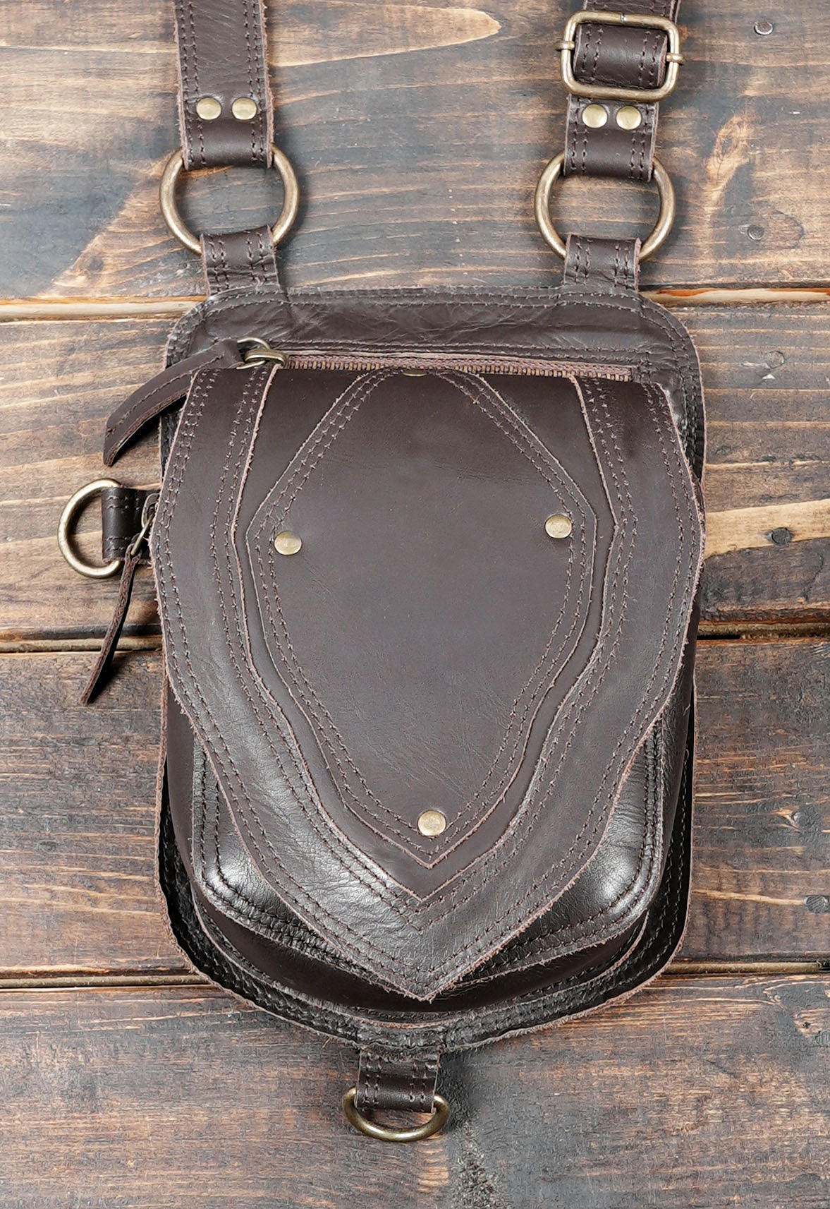 Adjustable leather shoulder holster with double front pockets and metal fasteners
