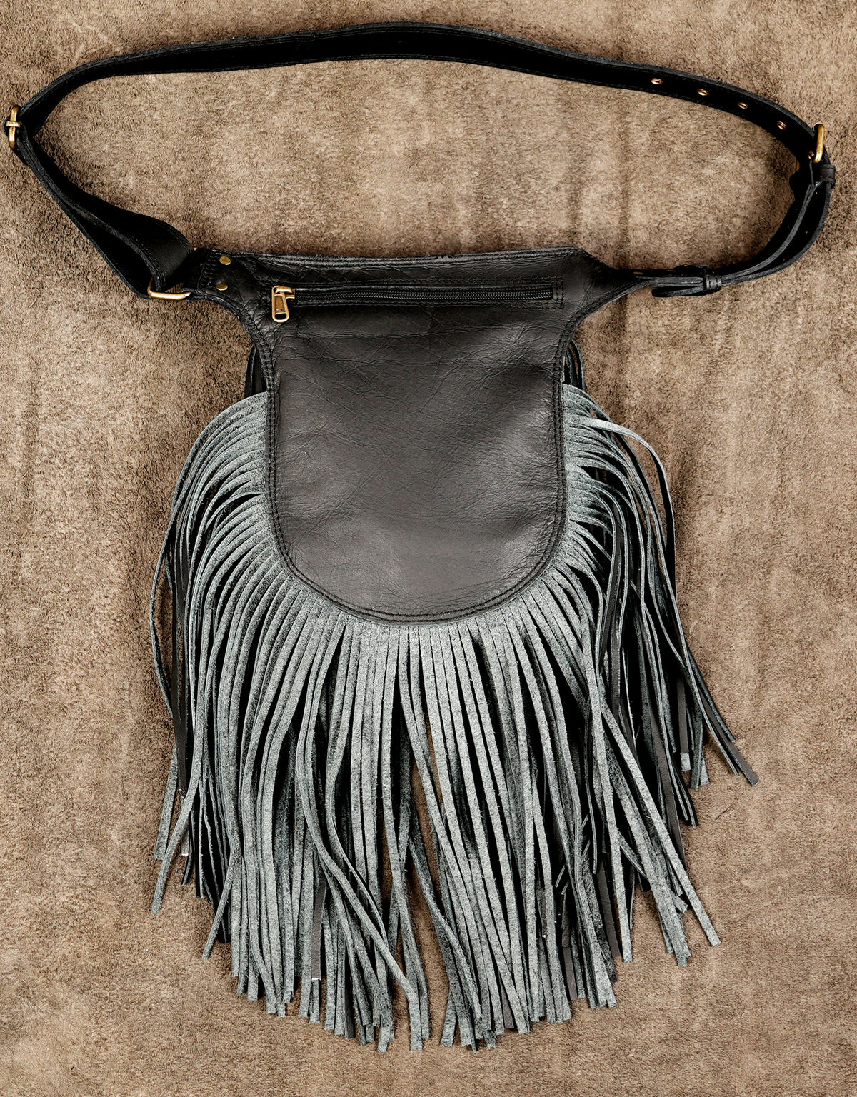 A black leather shoulder bag with a wide, adjustable strap and a large, fringed front pouch.