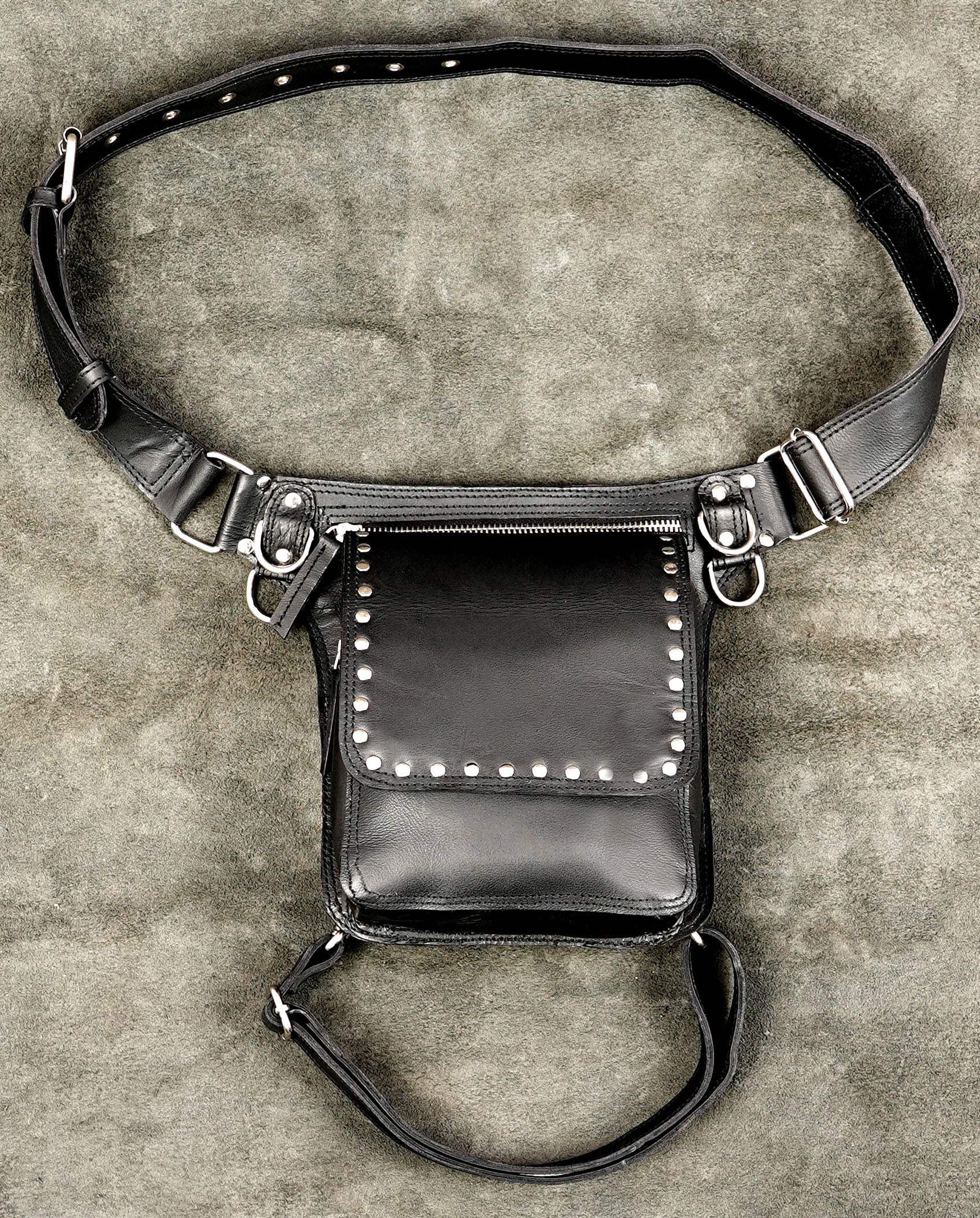 Studded black leather belt bag with integrated thigh harness.