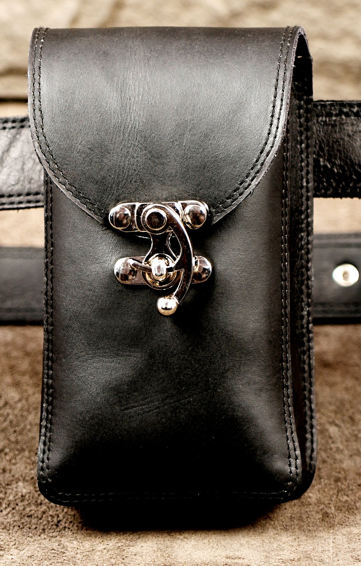 Minimalist leather holster with silver hardware accent