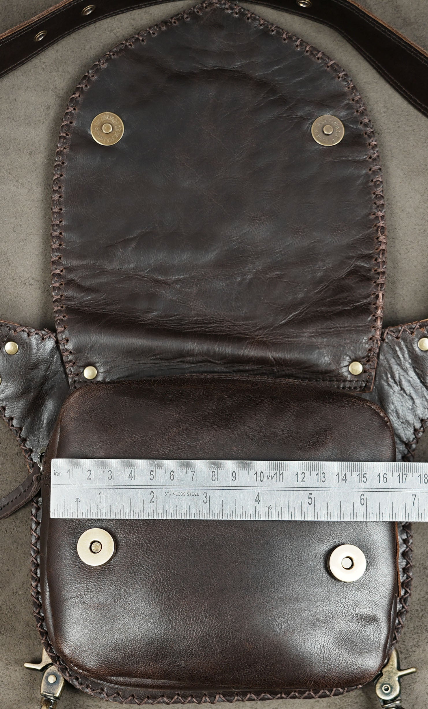 Rustic leather hip bag with brass studs and circular stitched design