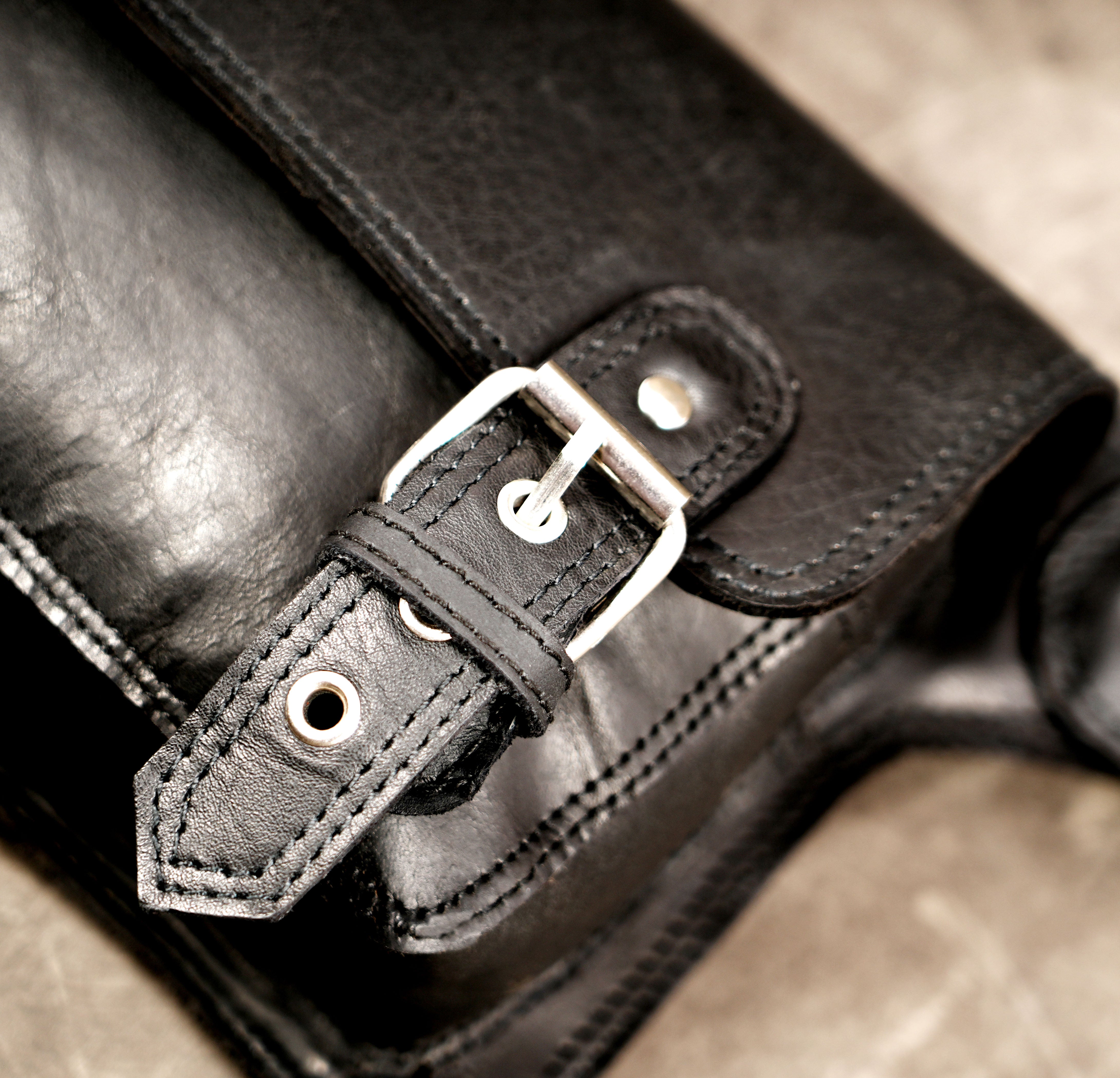 Satchel style leather pouch with buckle closure detail