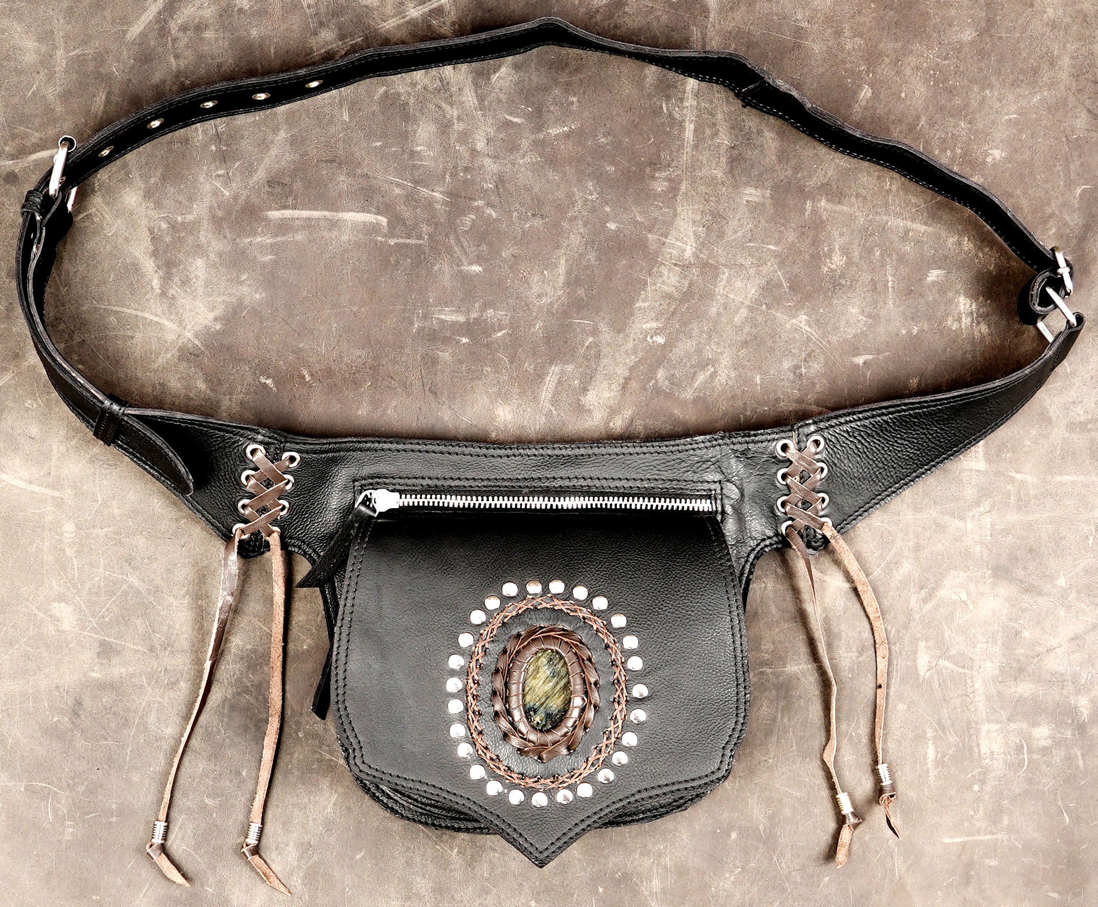 Shield shaped leather pouch with braided gem medallion