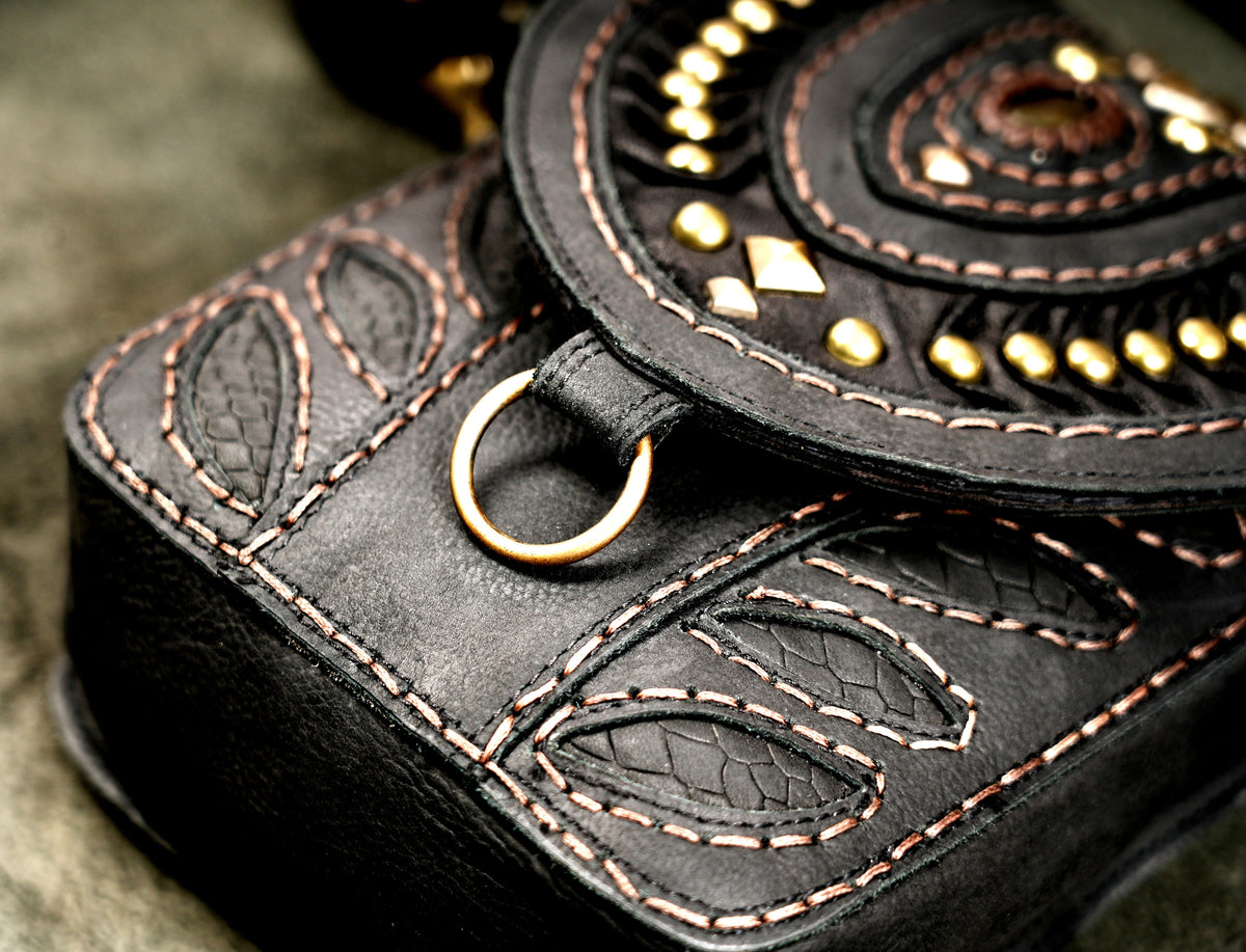 Rustic black leather belt bag with embossed reptile-texture leaf inlaysRustic black leather belt bag with embossed reptile-texture leaf inlays