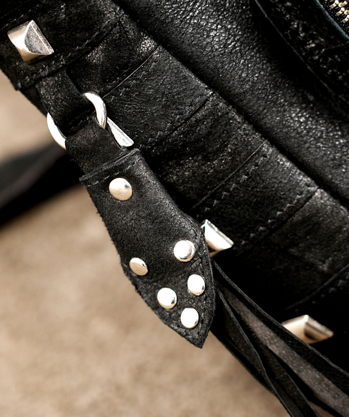 Studded leather saddle bag with long fringe on both sides