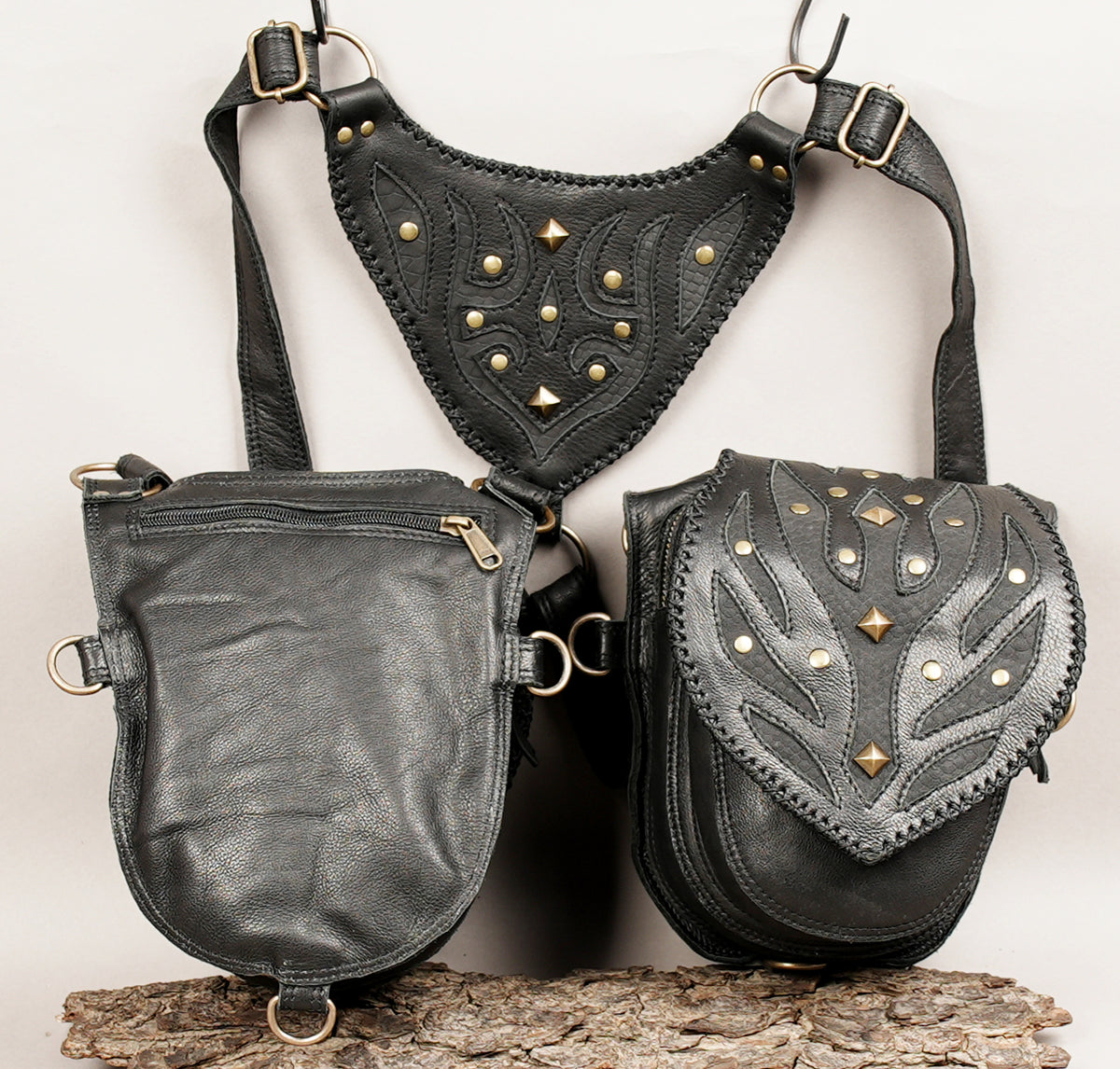 Three black leather shoulder and waist bags with brass studs and hardware.