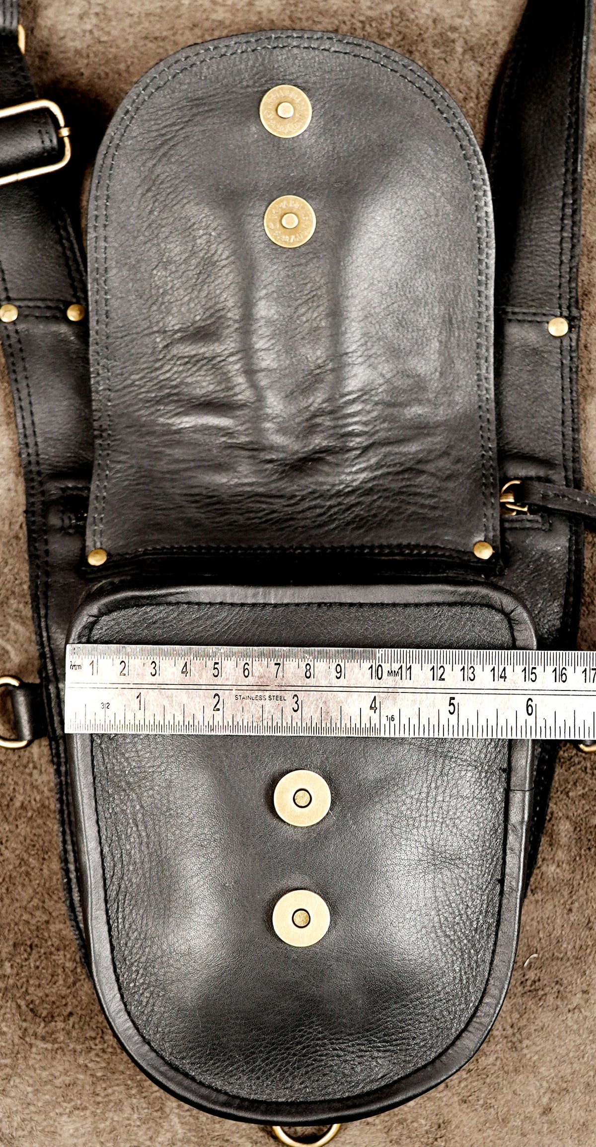 Steampunk double holster bag in black leather with orange detailing and adjustable buckled straps.
