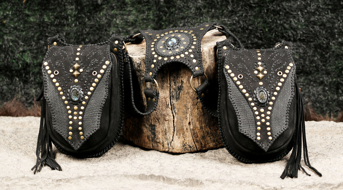 Unisex black leather shoulder harness with dual thigh pouches and decorative metal studs.