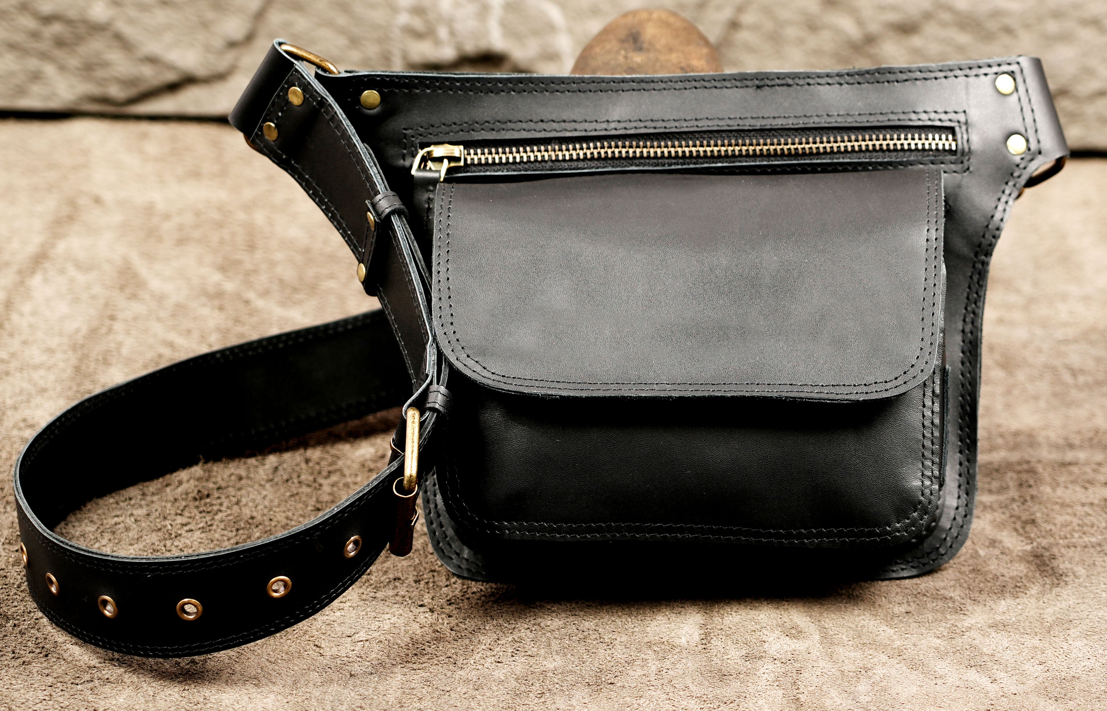 Leather fanny pack with brass buckle and flap closure