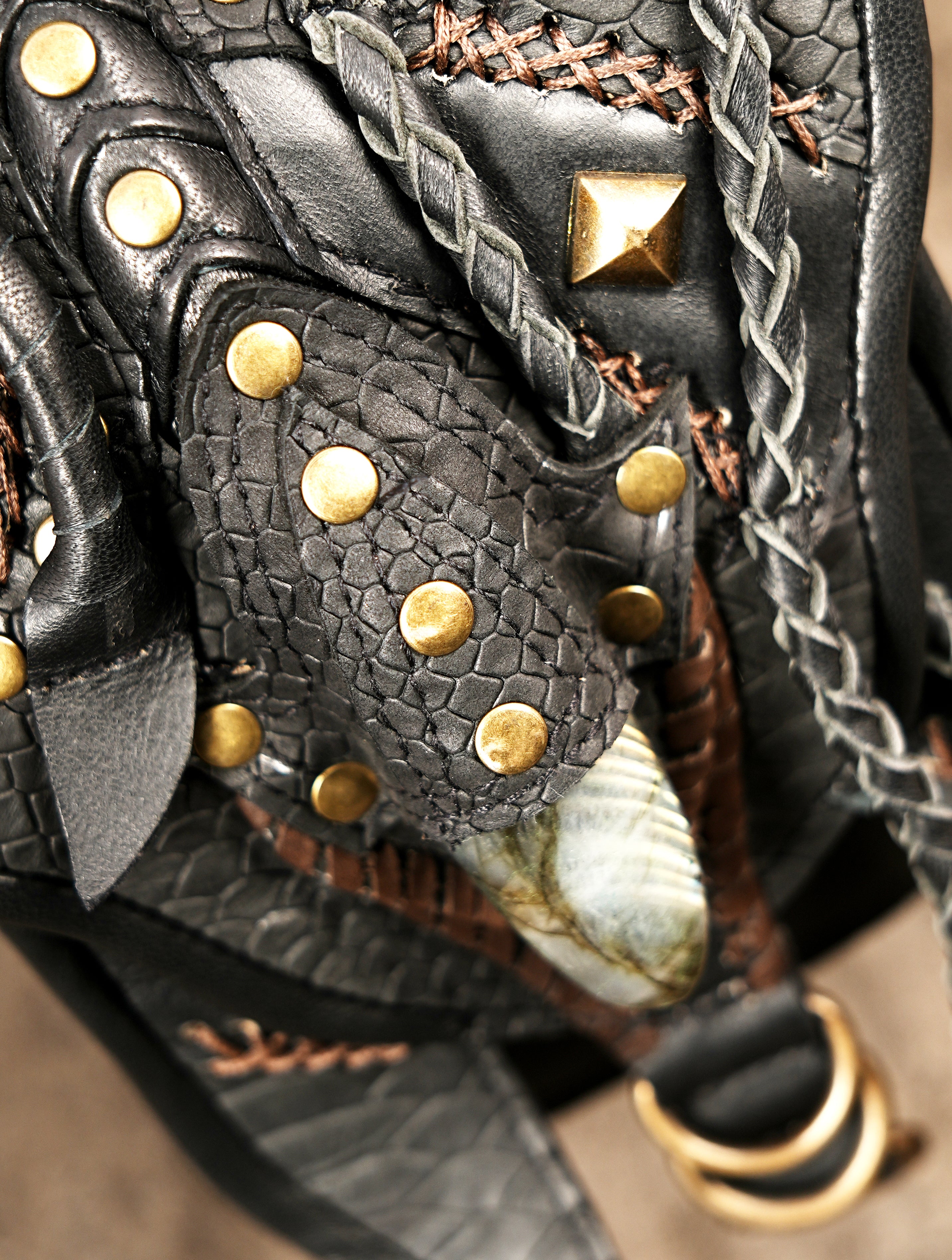  Black leather holster bag with detailed embroidery, braids, and brass fittings.