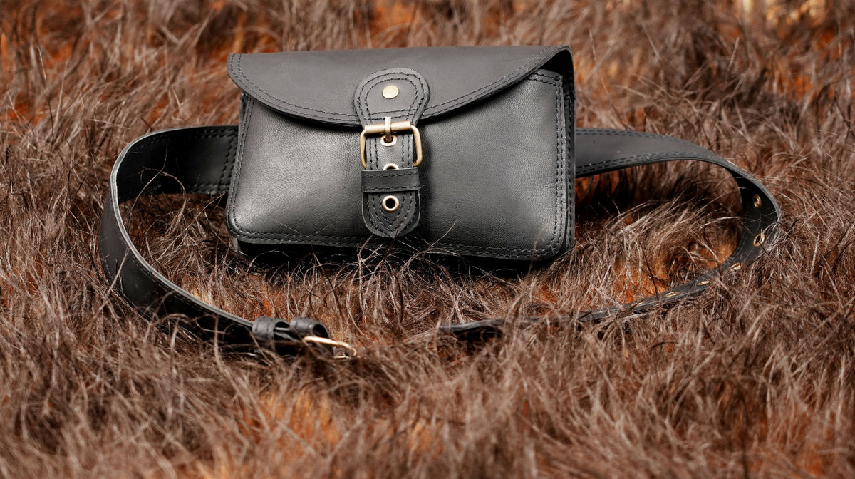 Fashionable black leather waist bag with metallic buckle detail   