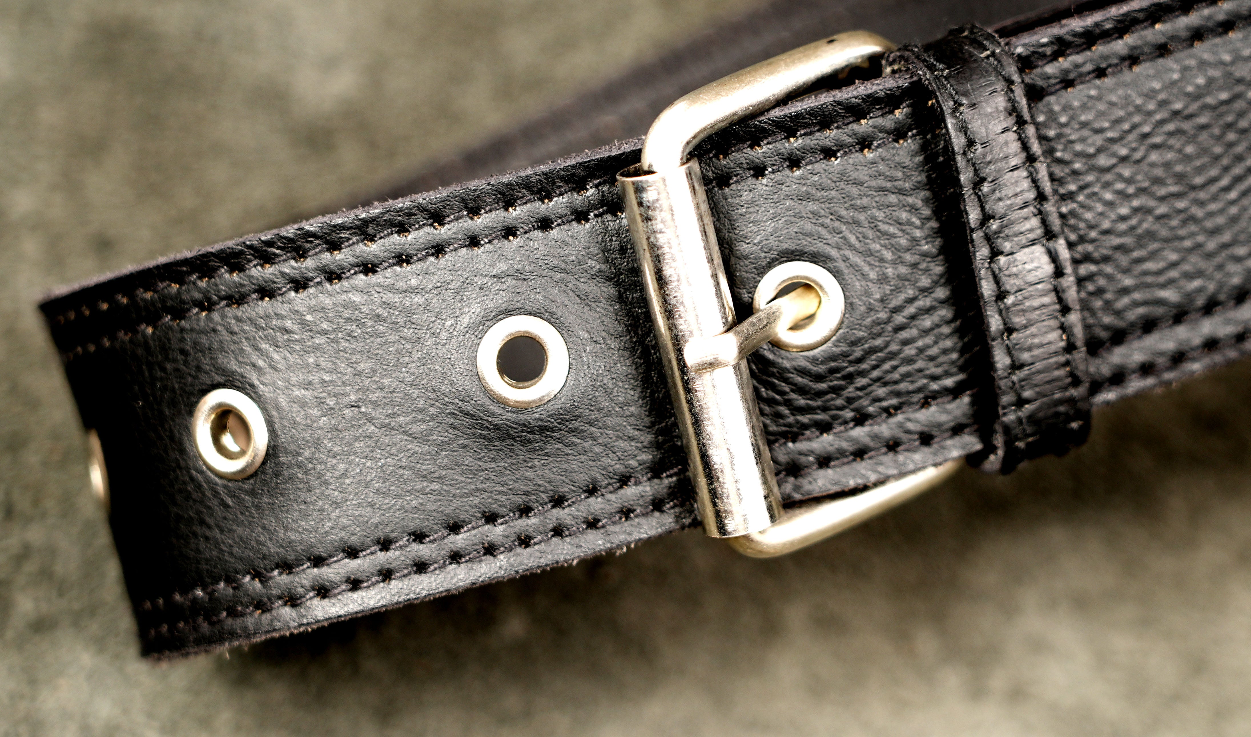 Studded black leather belt bag with integrated thigh harness.