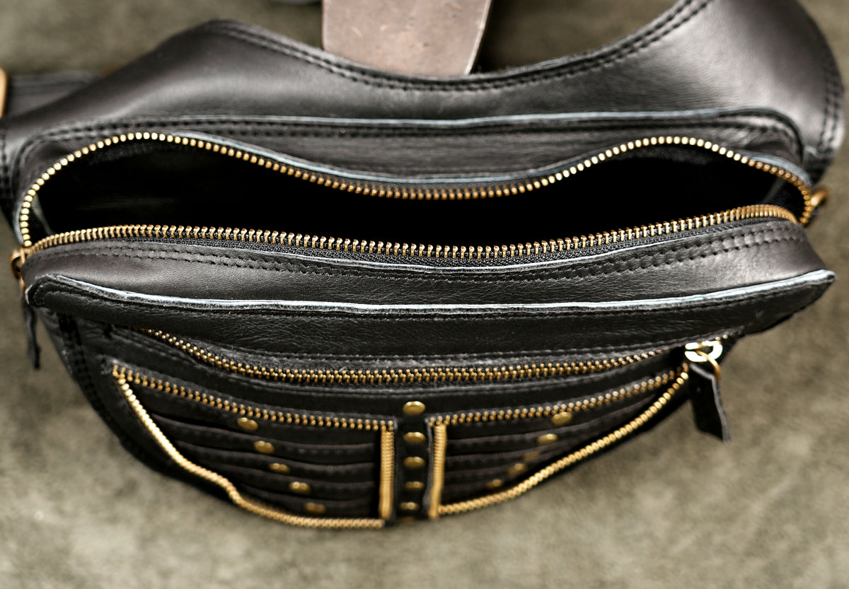 Handmade leather chest bag with decorative studs and zip pockets
