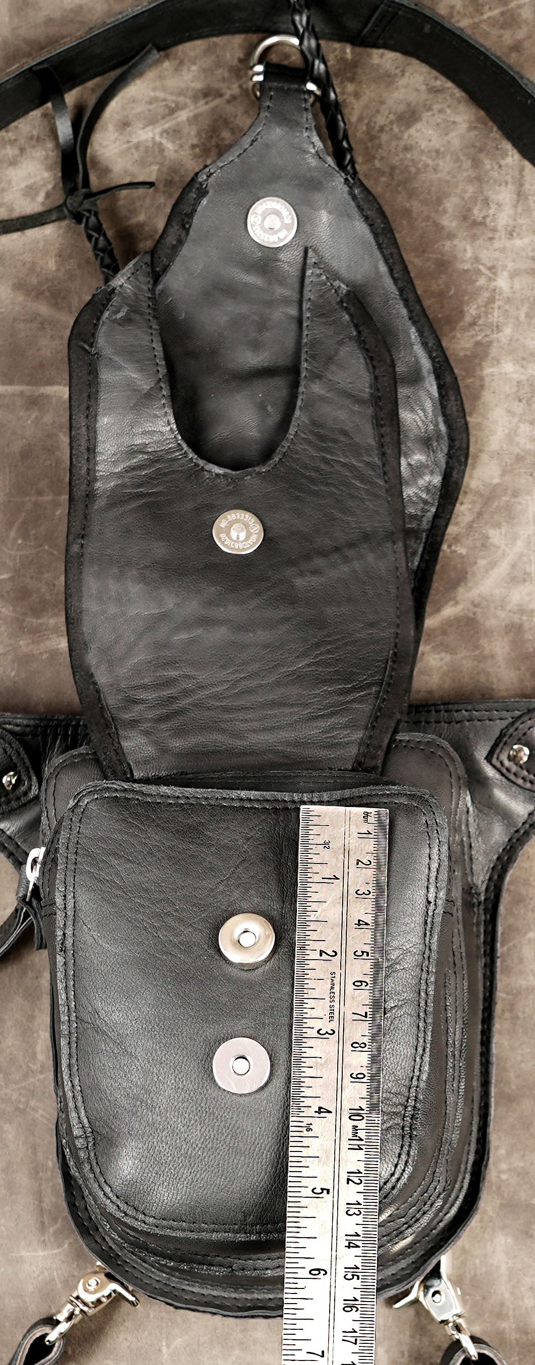 Unique black leather utility pouch with intricate stitching and rings