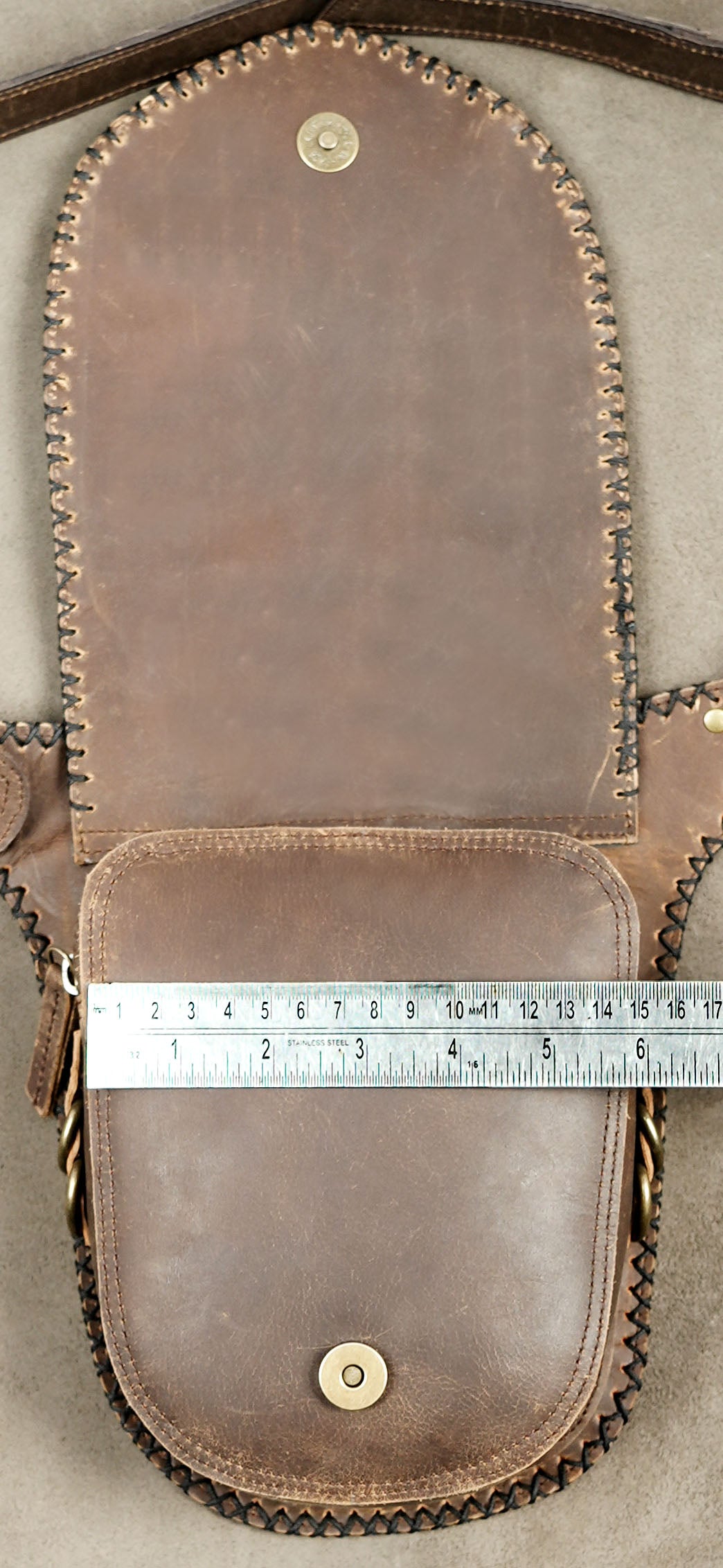 Handcrafted brown leather waist pouch with decorative brass D-rings.