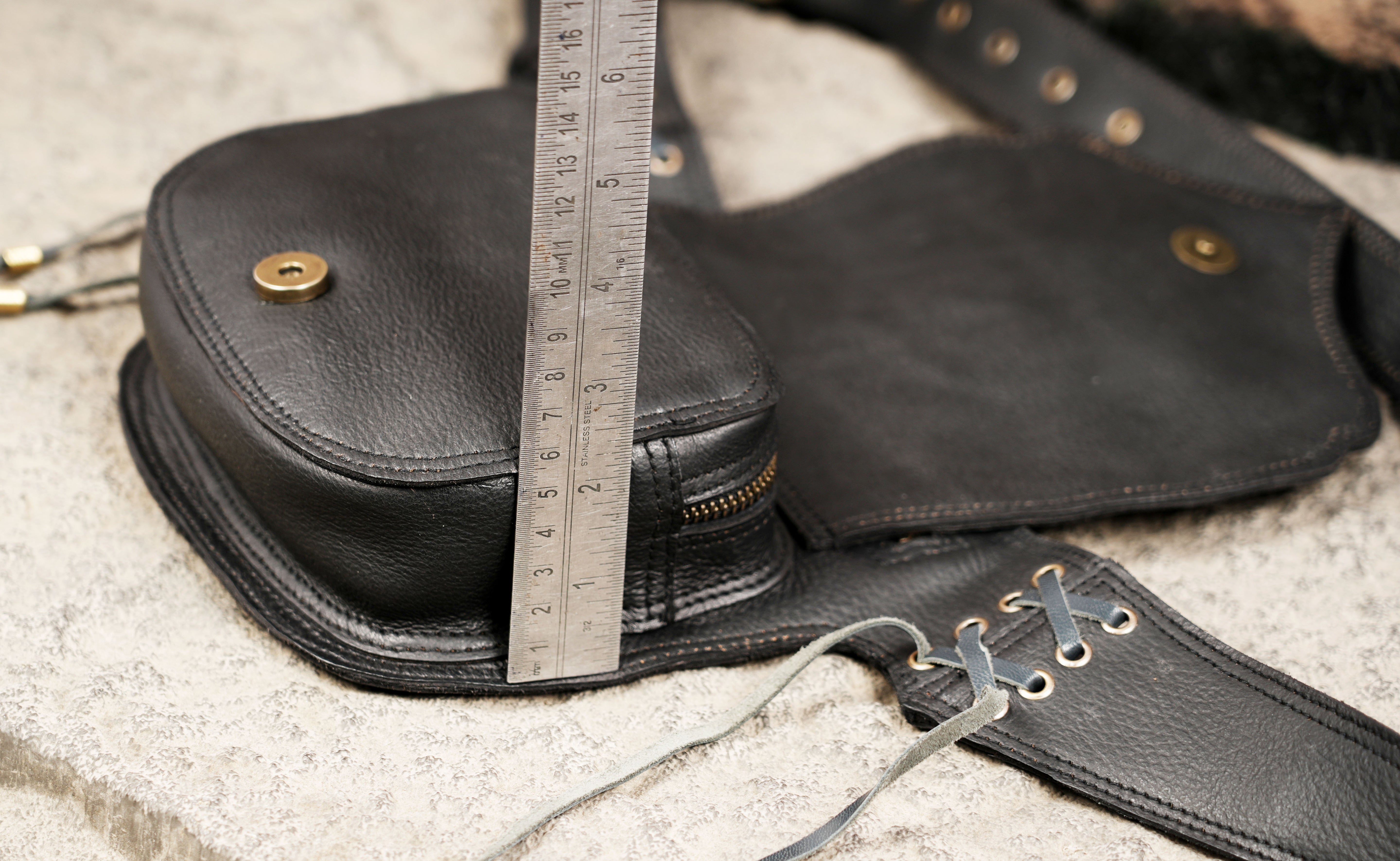 Leather festival hip bag with gemstone accent, lace-up sides and adjustable waist belt.