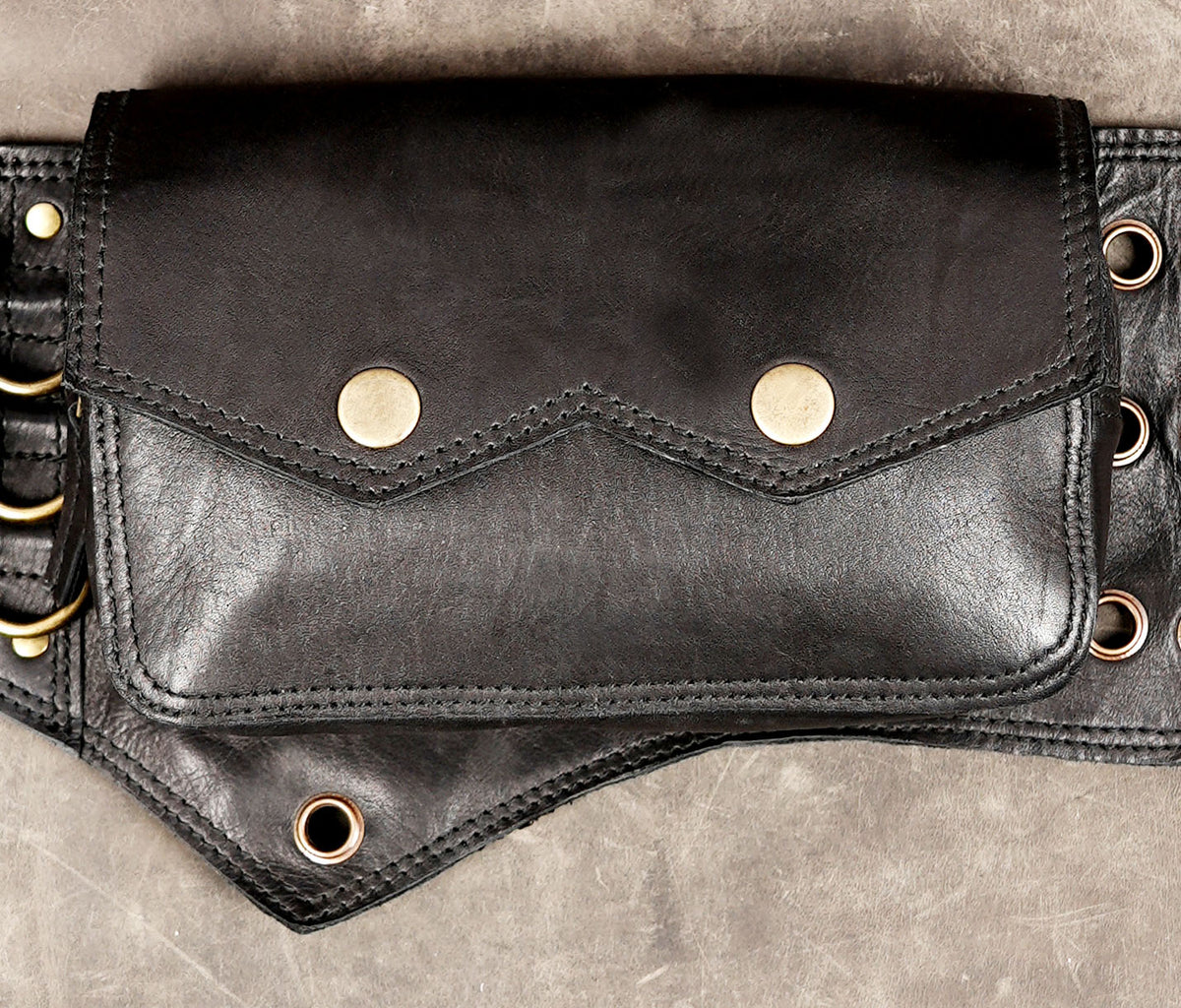 UNISEX leather waist belt with adjustable buckle straps and metal ring details.

