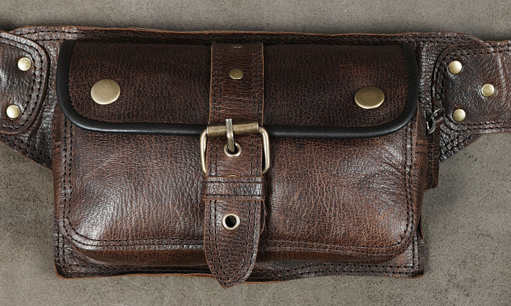 Adjustable brown leather hip belt featuring two storage pockets