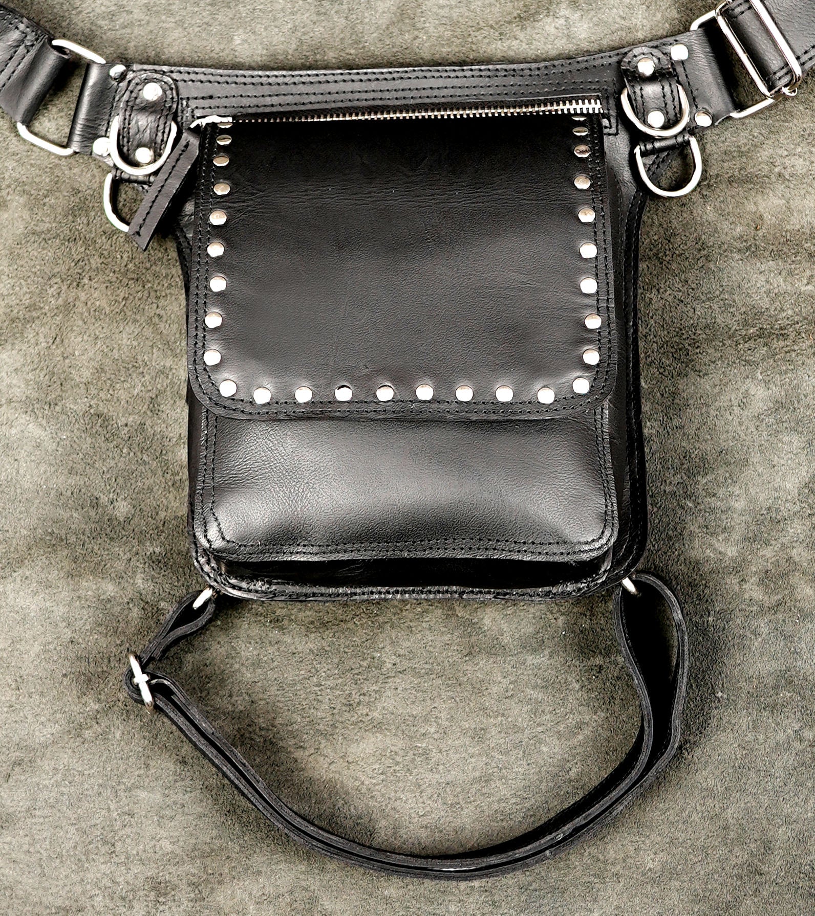 Punk style black leather leg bag with silver metal hardware.
