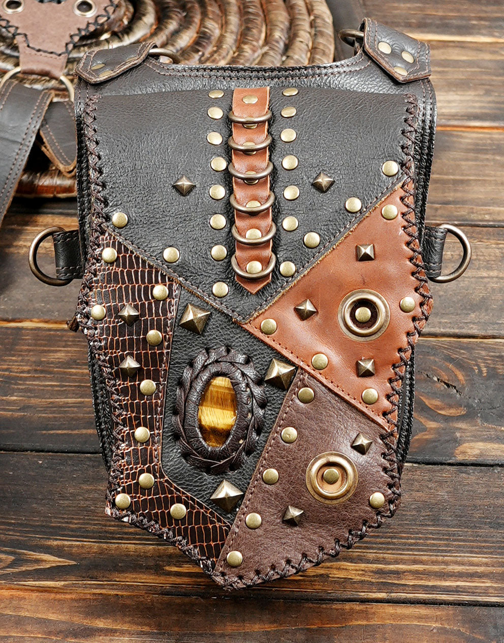 Brown and black leather hip holster with detailed stitching and metal studs