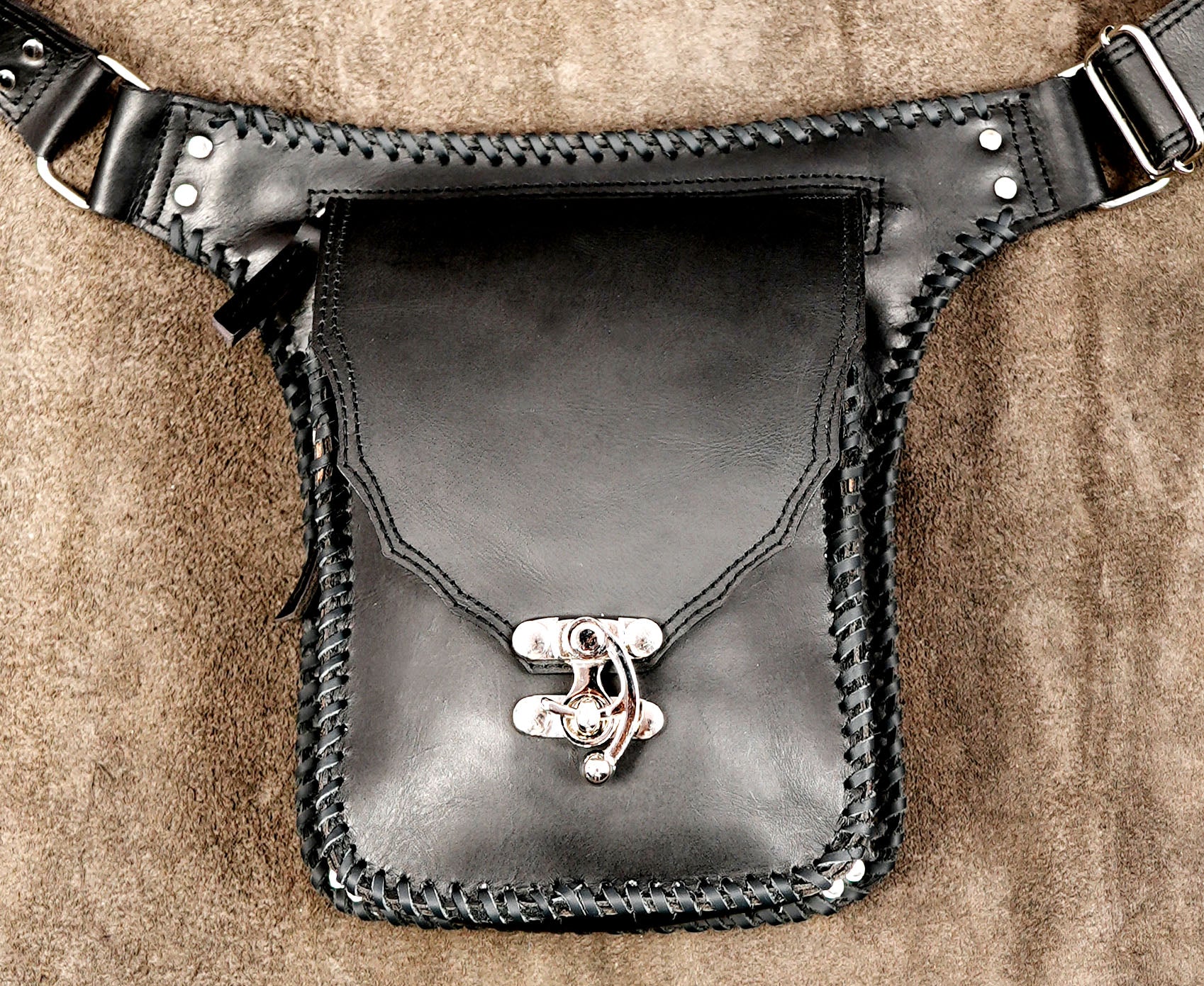 Genuine leather belt pouch featuring braided trim and silver hardware.