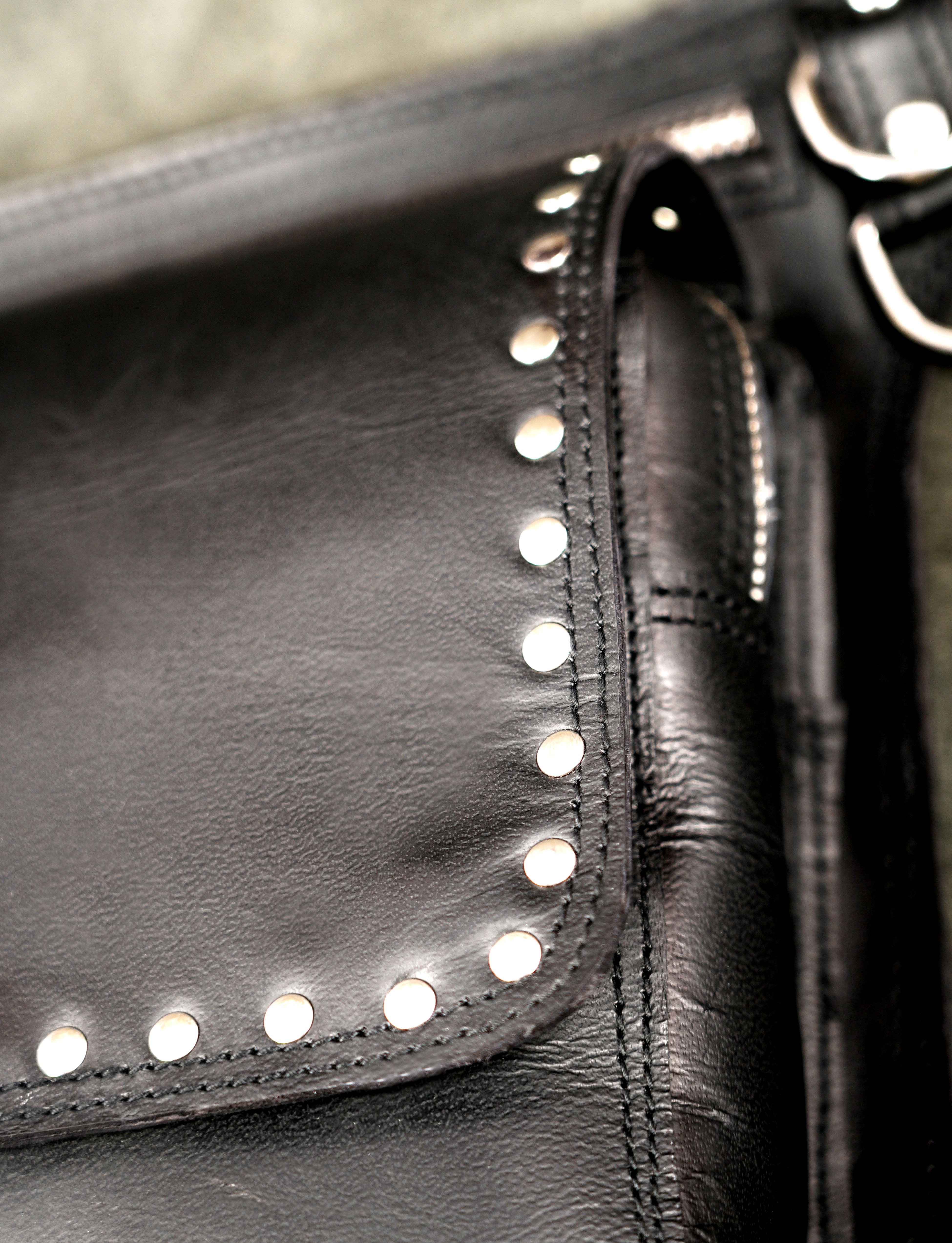 Secure zippered black leather thigh holster pack with studded design.