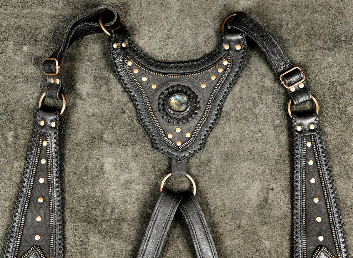 Black leather utility harness bag with dual side pouches designed as a statement body accessory for women