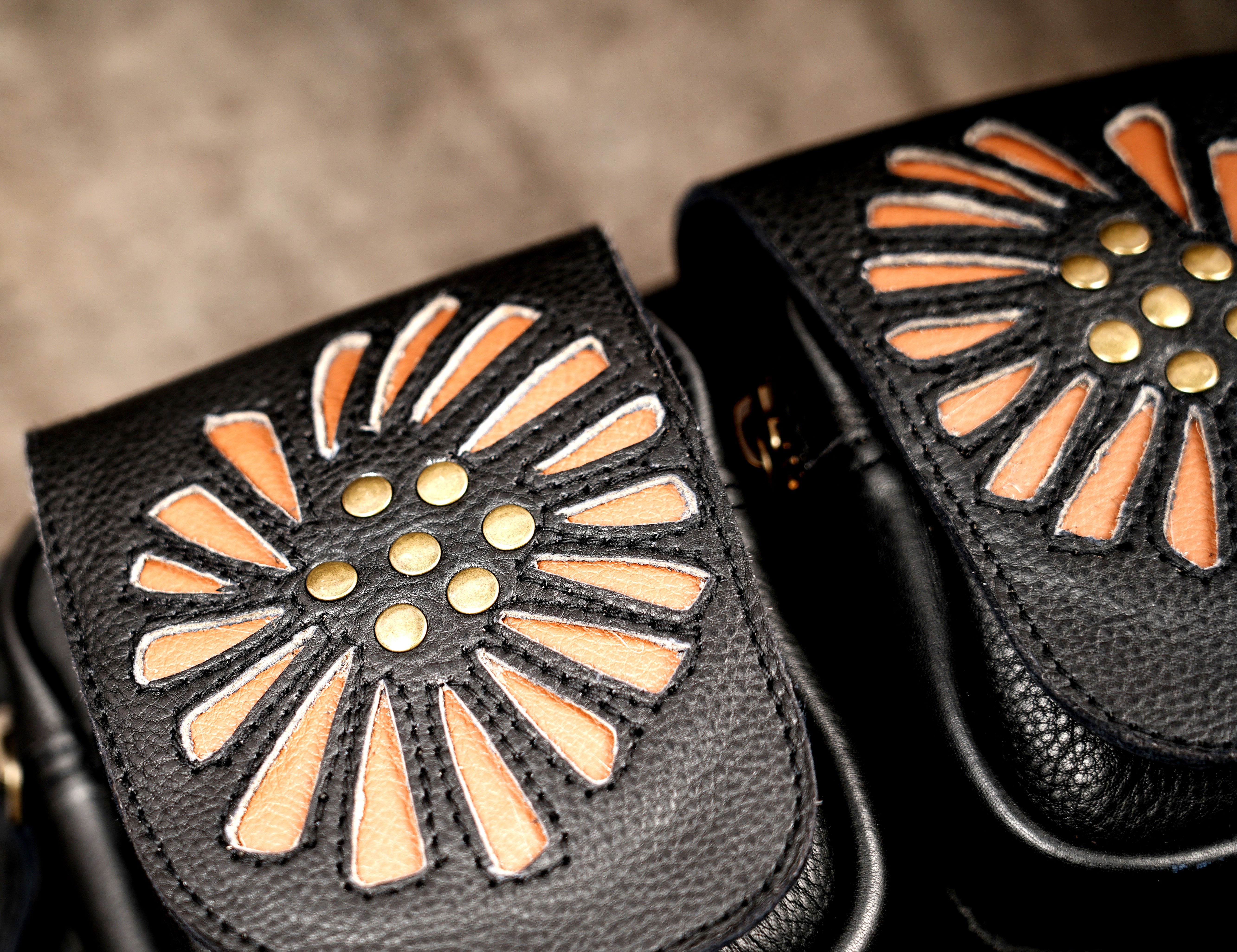 Adjustable leather waist pouch with two floral flaps and antique brass fittings.