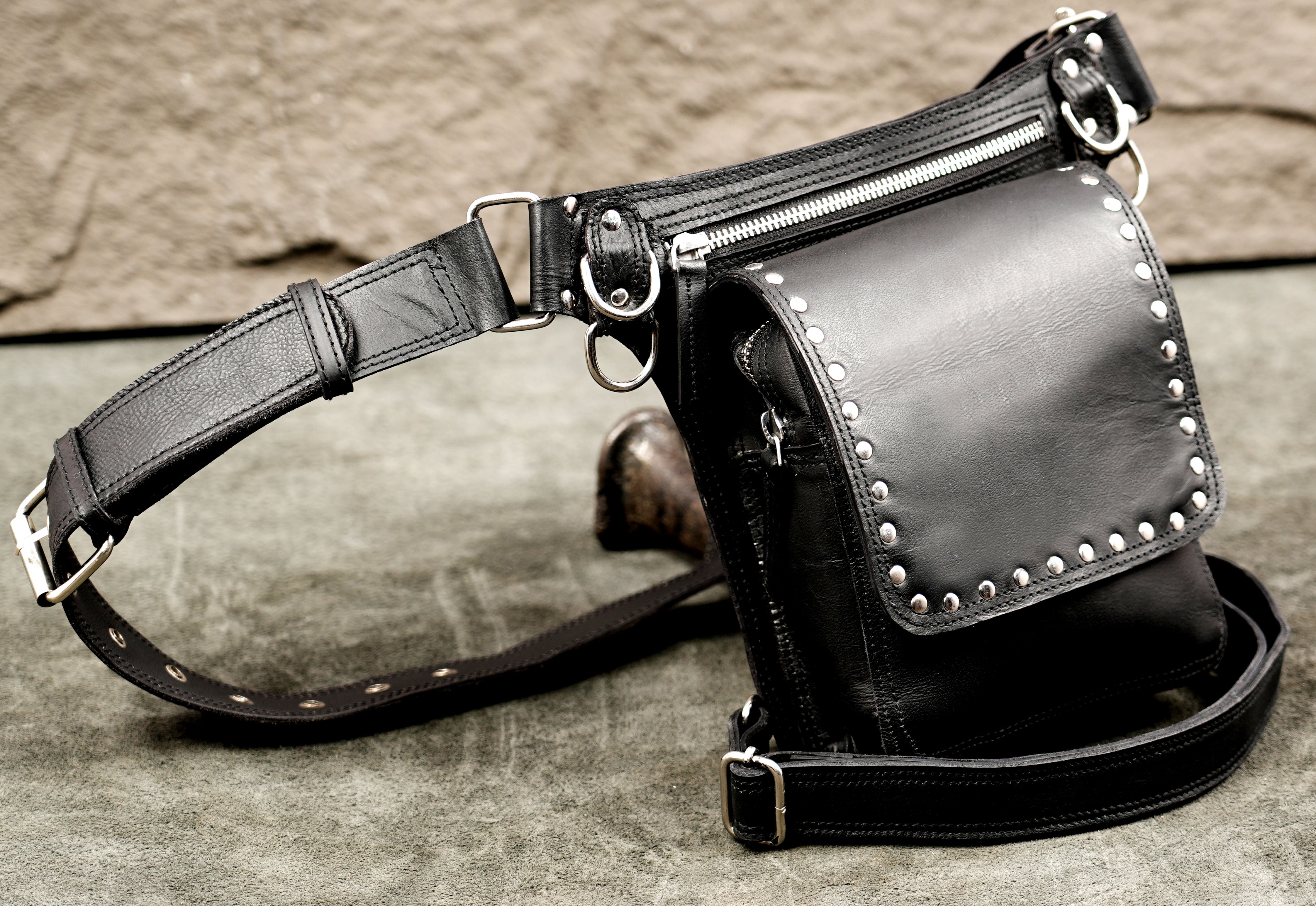 Motorcycle drop leg bag in black leather with silver accents.