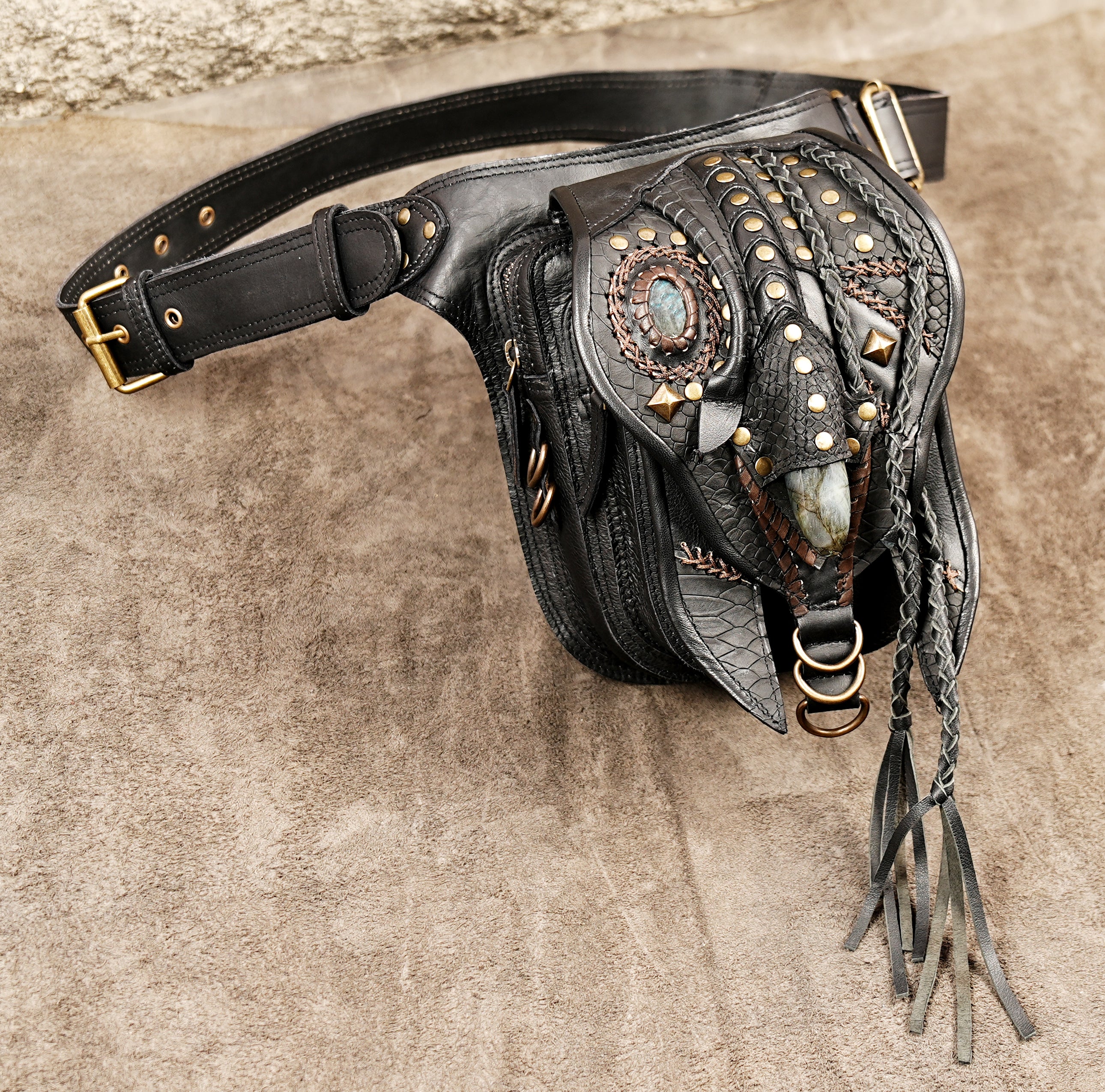Gothic black leather hip bag with brass studs and textured snakeskin pattern accents.