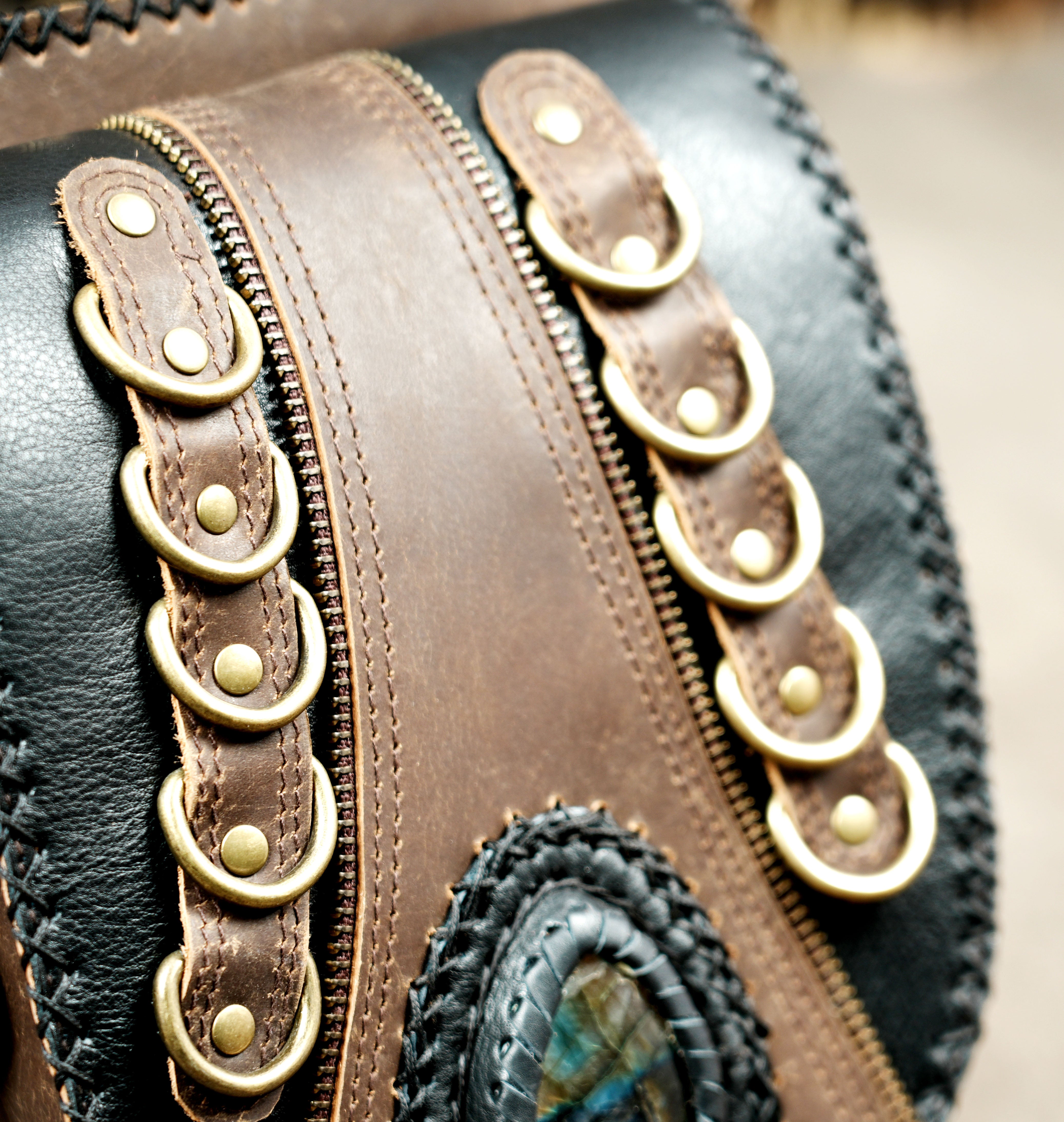 Handmade leather waist bag with labradorite stone and detailed stitching.