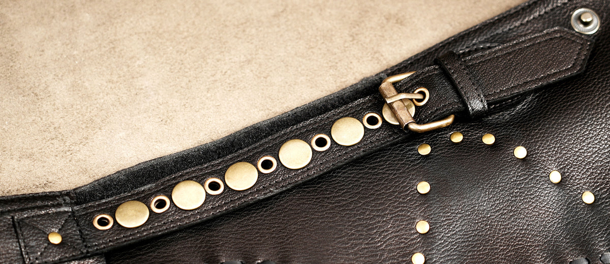 Dark brown bohemian leather skirt with black whipstitch edges and metal studs