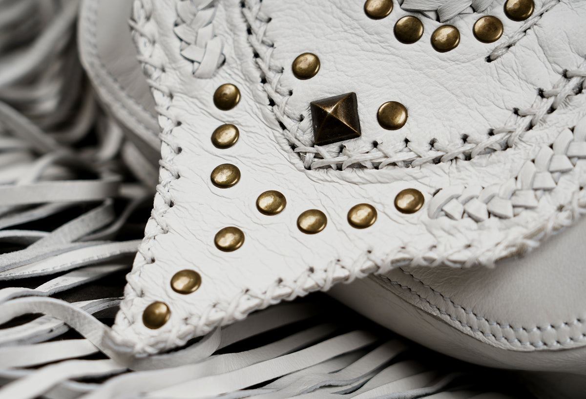 White leather hip bag with Western fringe and studded details

