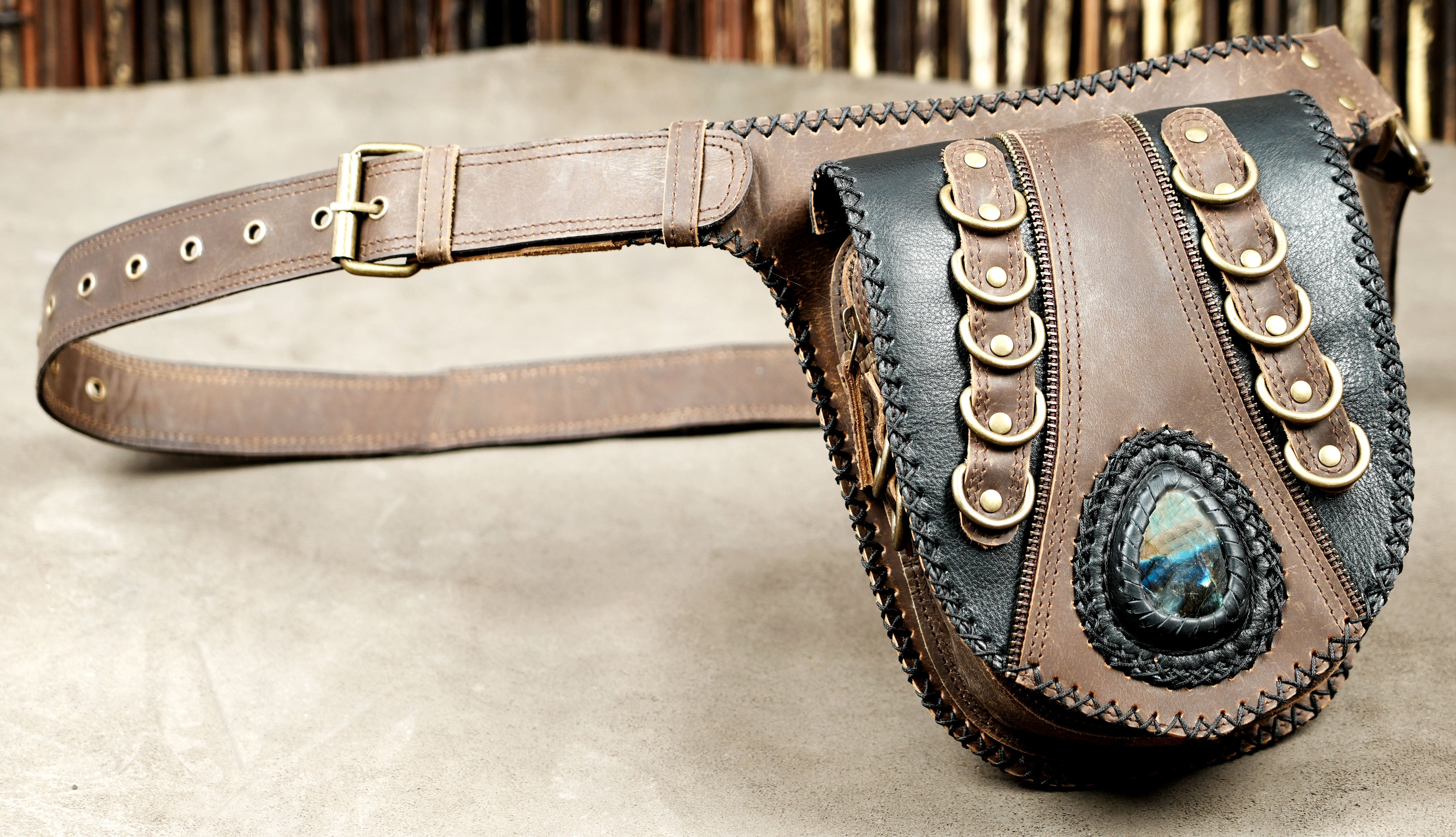 Brown leather waist pouch with black accents and antique brass hardware.