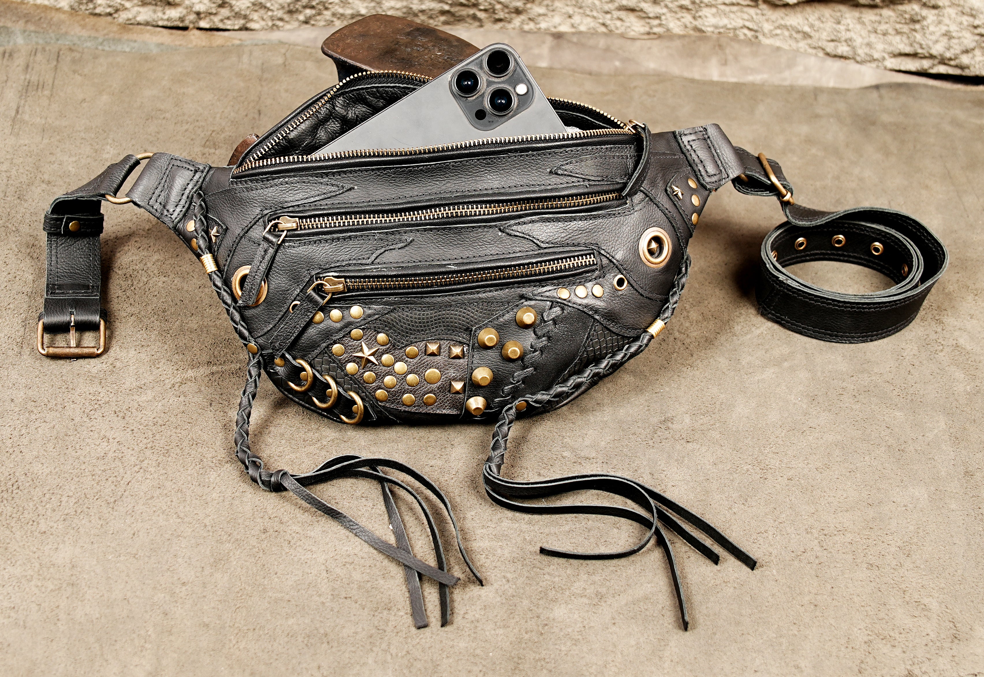 Black leather utility belt bag with motorcycle punk hardware, zippers, and studded accents.