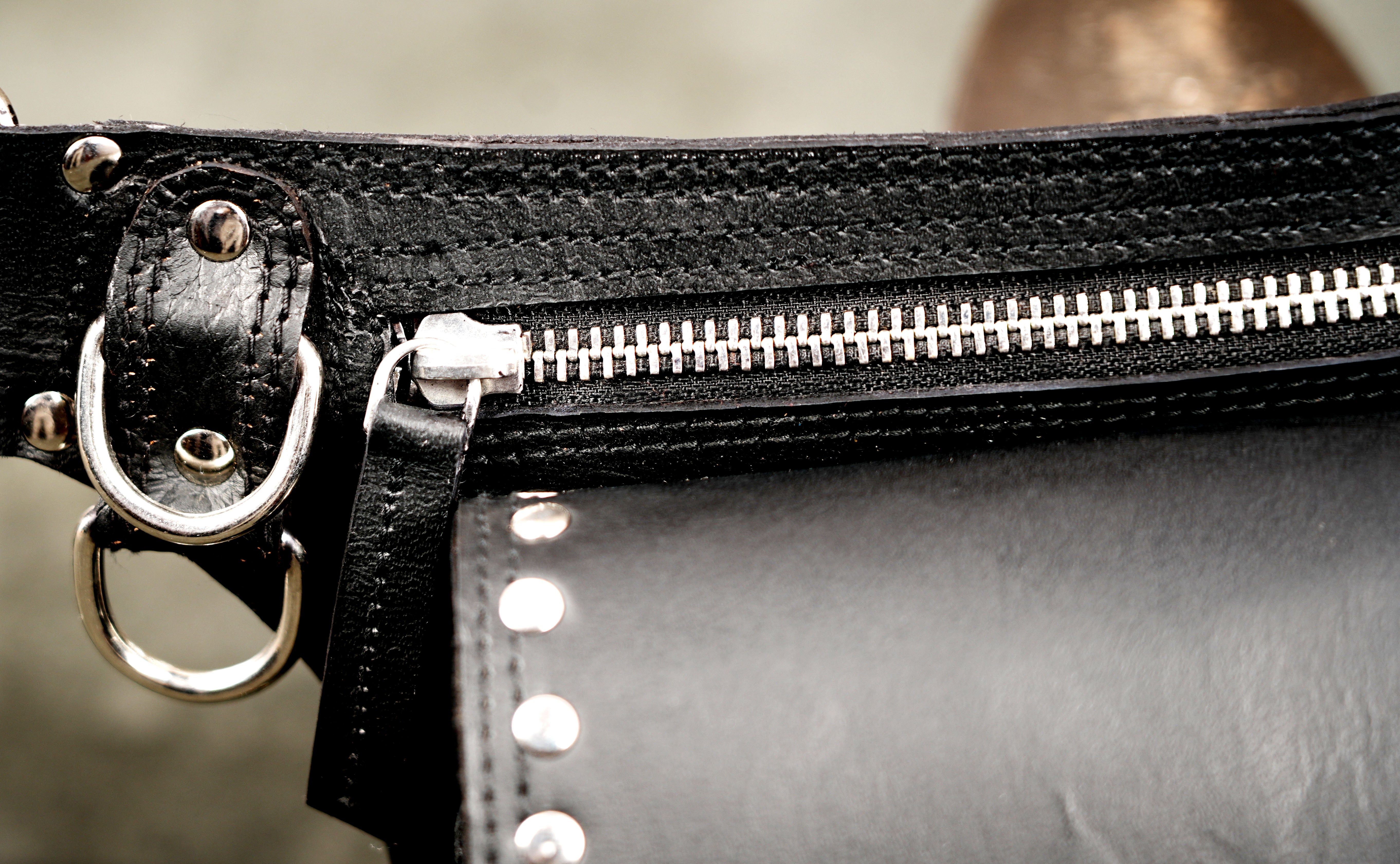 Secure zippered black leather thigh holster pack with studded design.