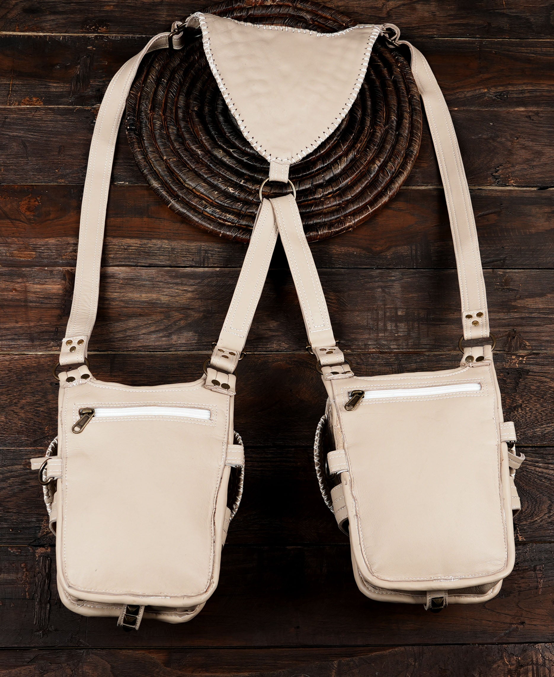 Detailed stitching and woven patterns on a cream-colored dual pocket leather utility harness.