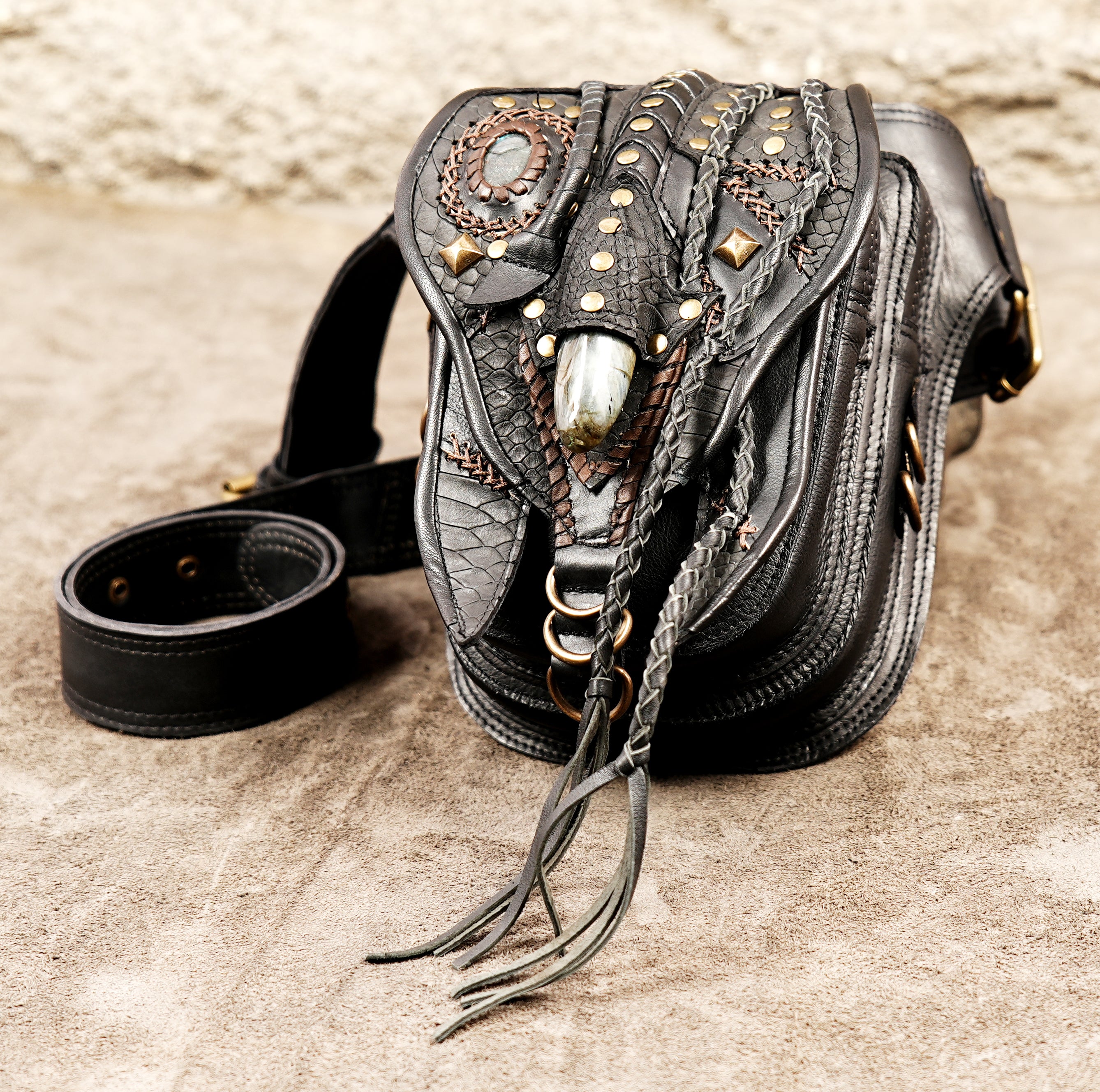 Heavy-duty black leather utility belt pouch with multiple textures and sturdy brass rivets.