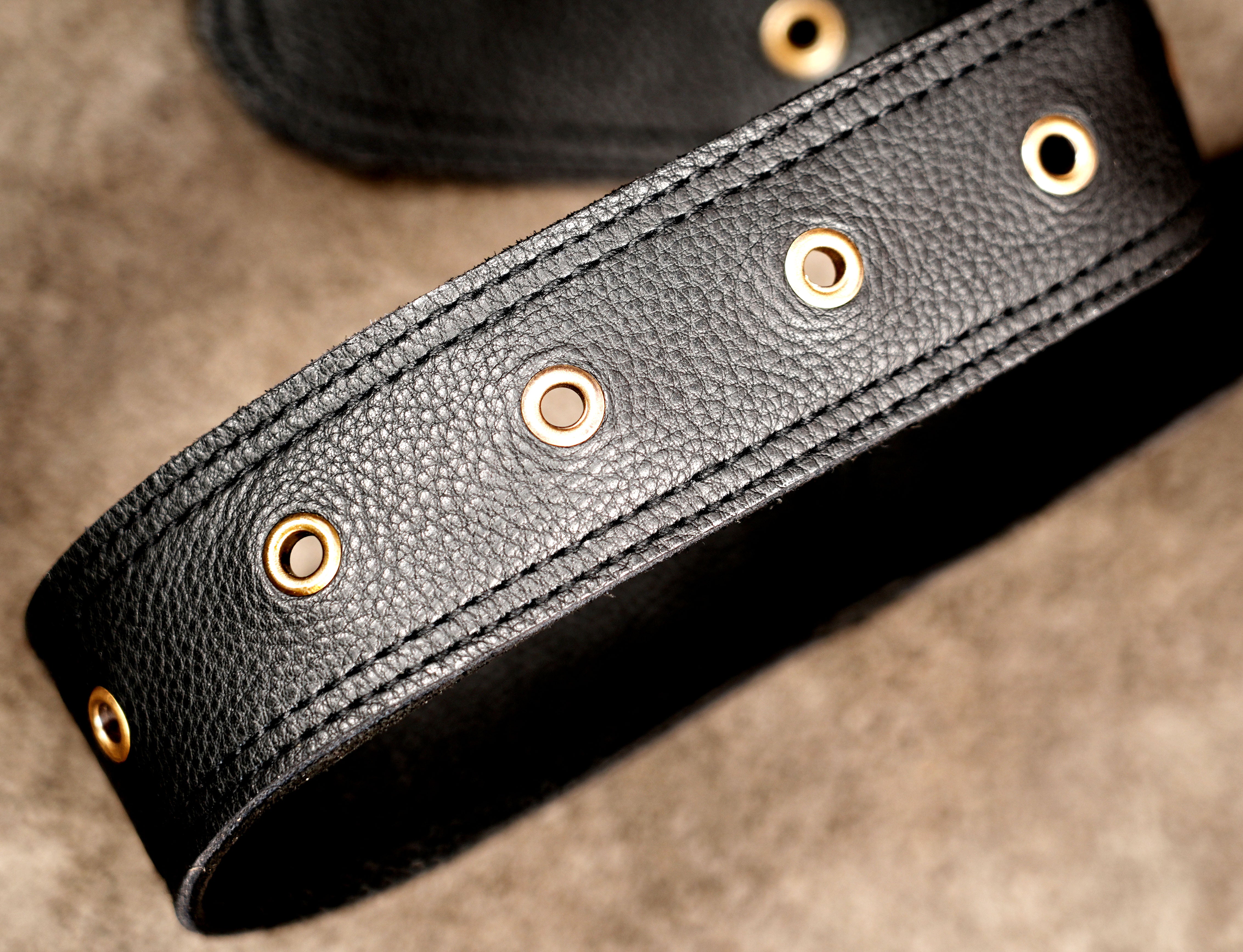 Hands-free leather waist bag with twin storage pouches and floral cutwork.