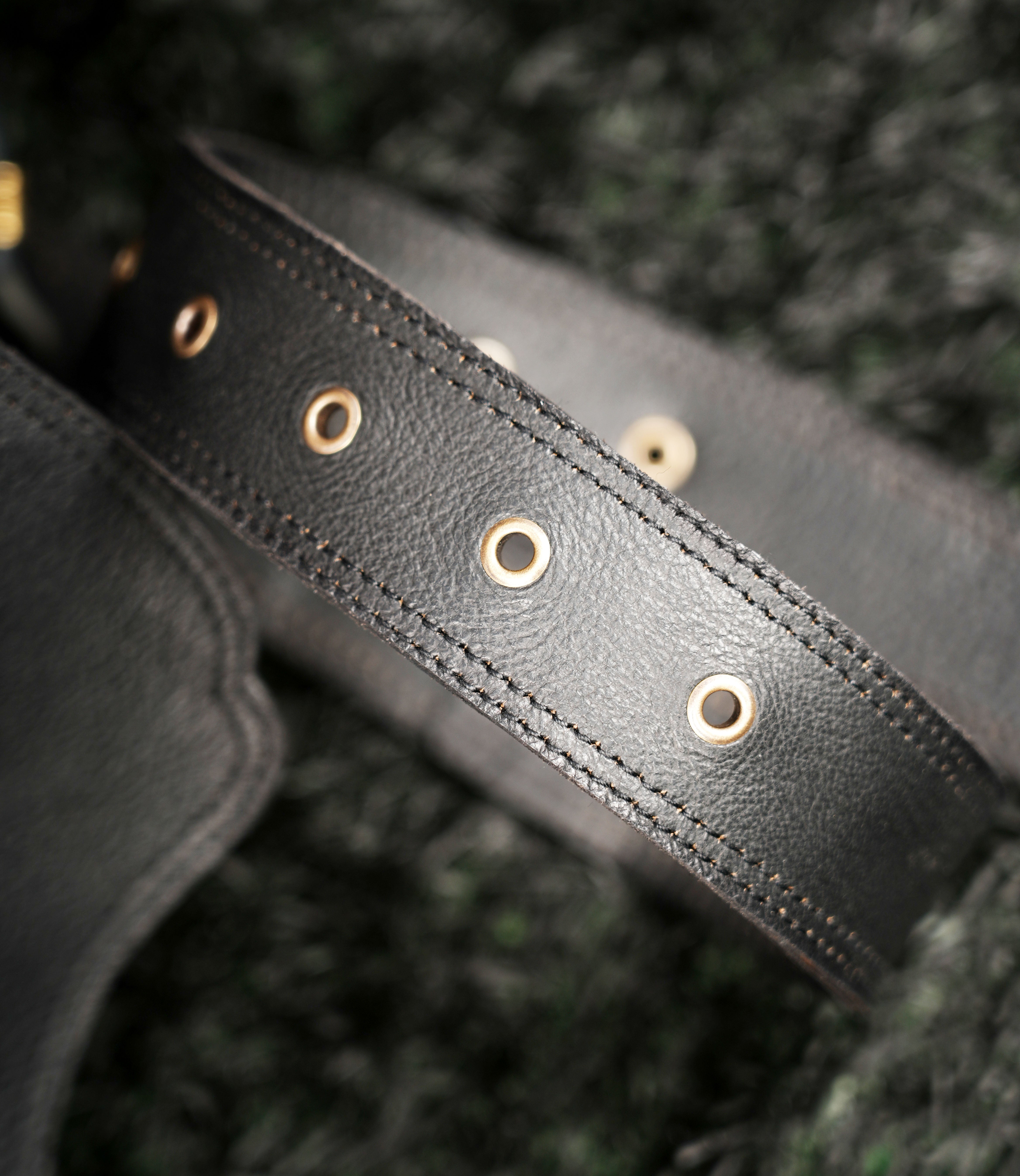 Handmade leather hip belt bag with gemstone flap, zipper storage and decorative side lacing.